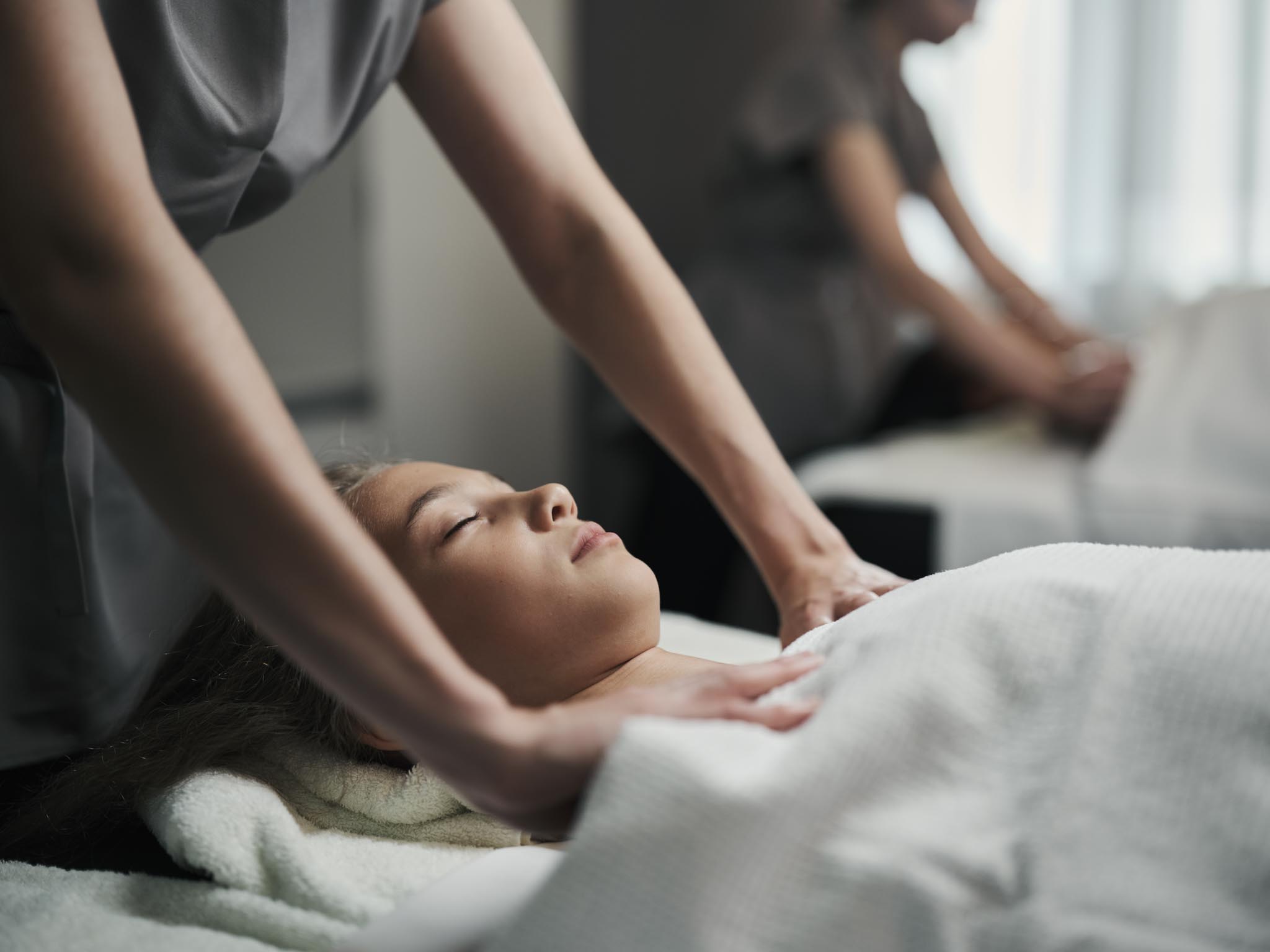 Frau bekommt eine Massage im Behandlungsraum des Alpenrose Familux Resorts.