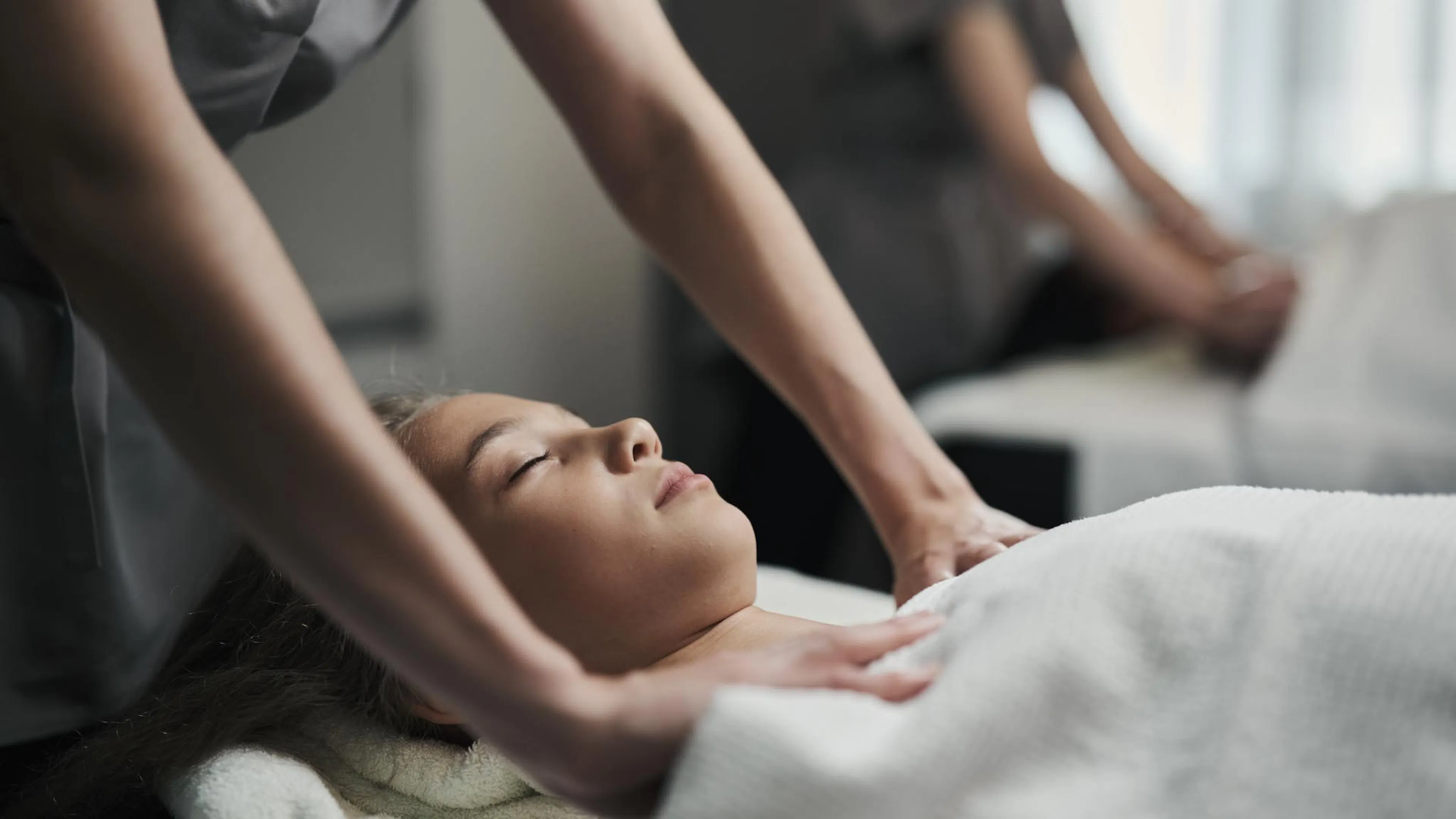 Frau bekommt eine Massage im Behandlungsraum des Alpenrose Familux Resorts.