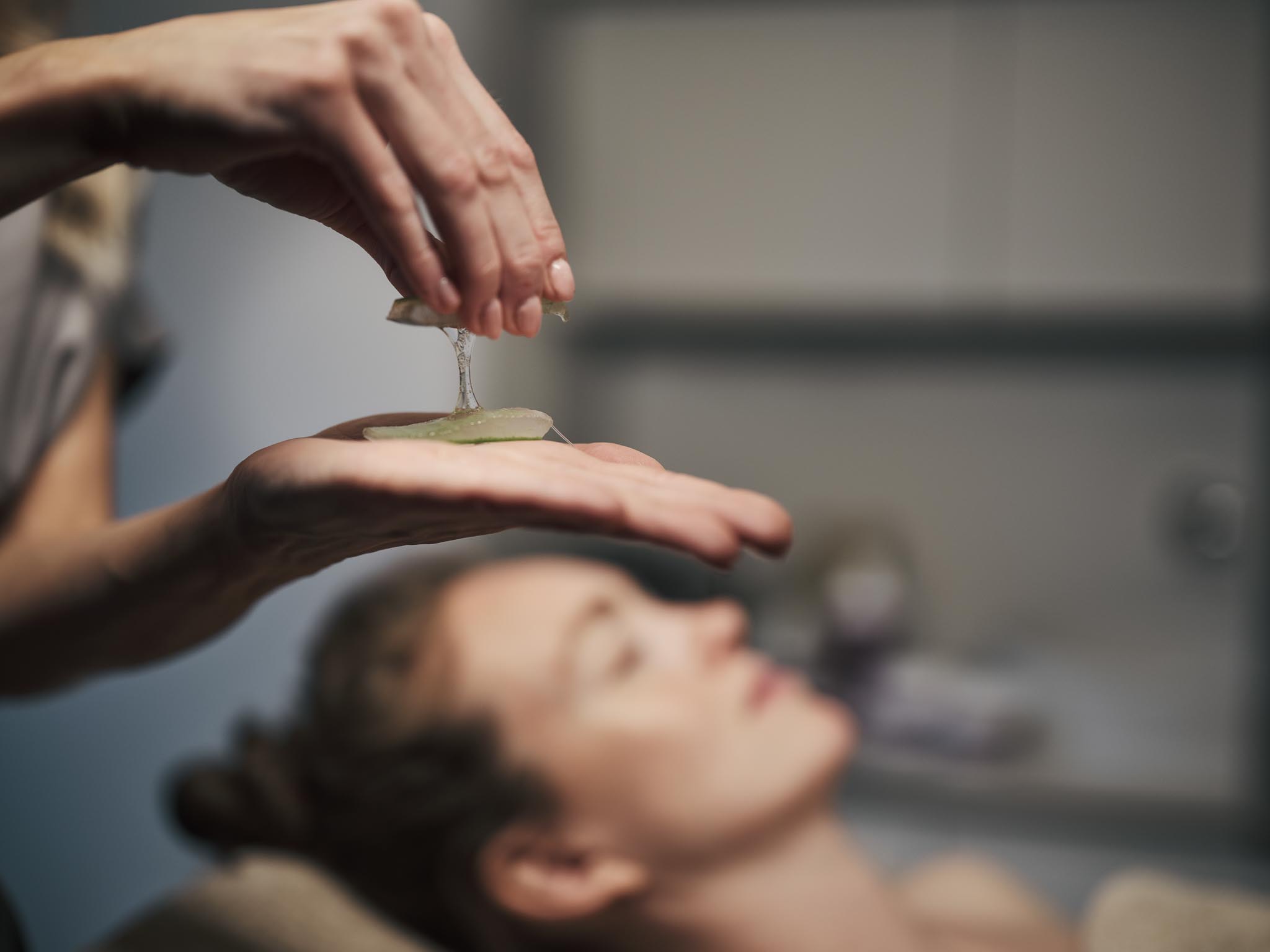 Kosmetikerin behandelt mit einer Aloe Vera Pflanze im Spa des Alpenrose Familux Resorts.