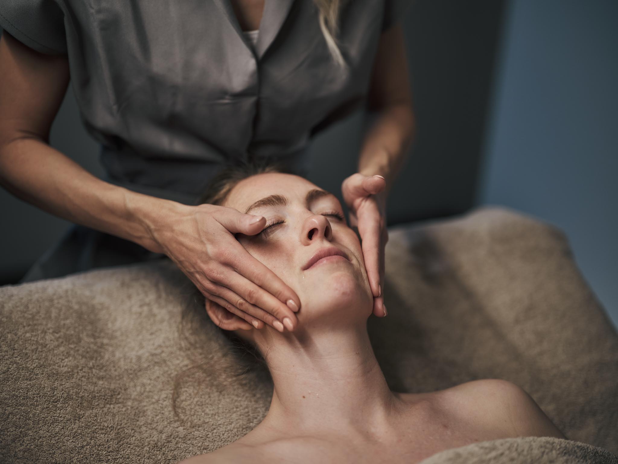 Frau bei Gesichtsbehandlung in einem Behandlungsraum des Alpenrose Familux Resorts.