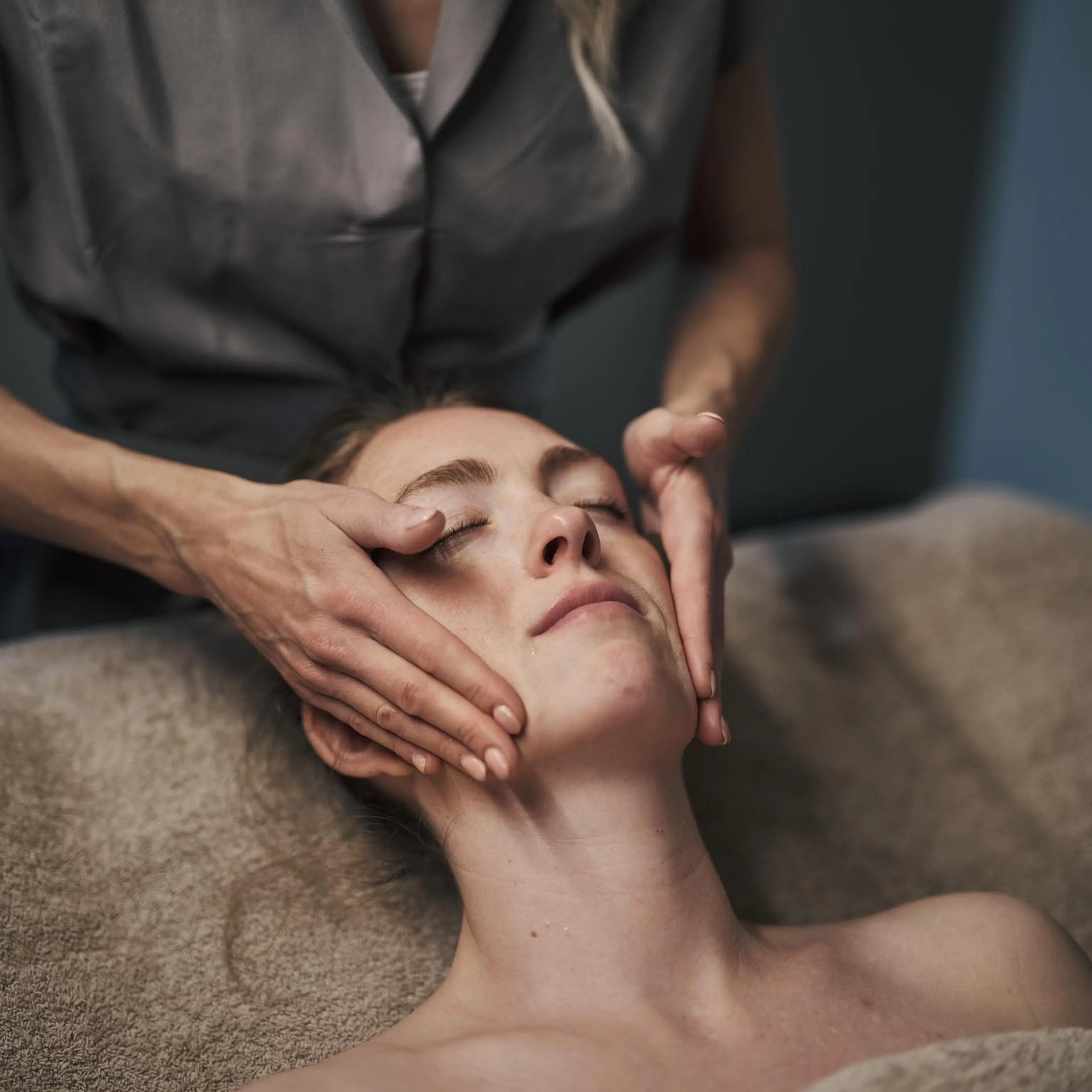 Frau bei Gesichtsbehandlung in einem Behandlungsraum des Alpenrose Familux Resorts.
