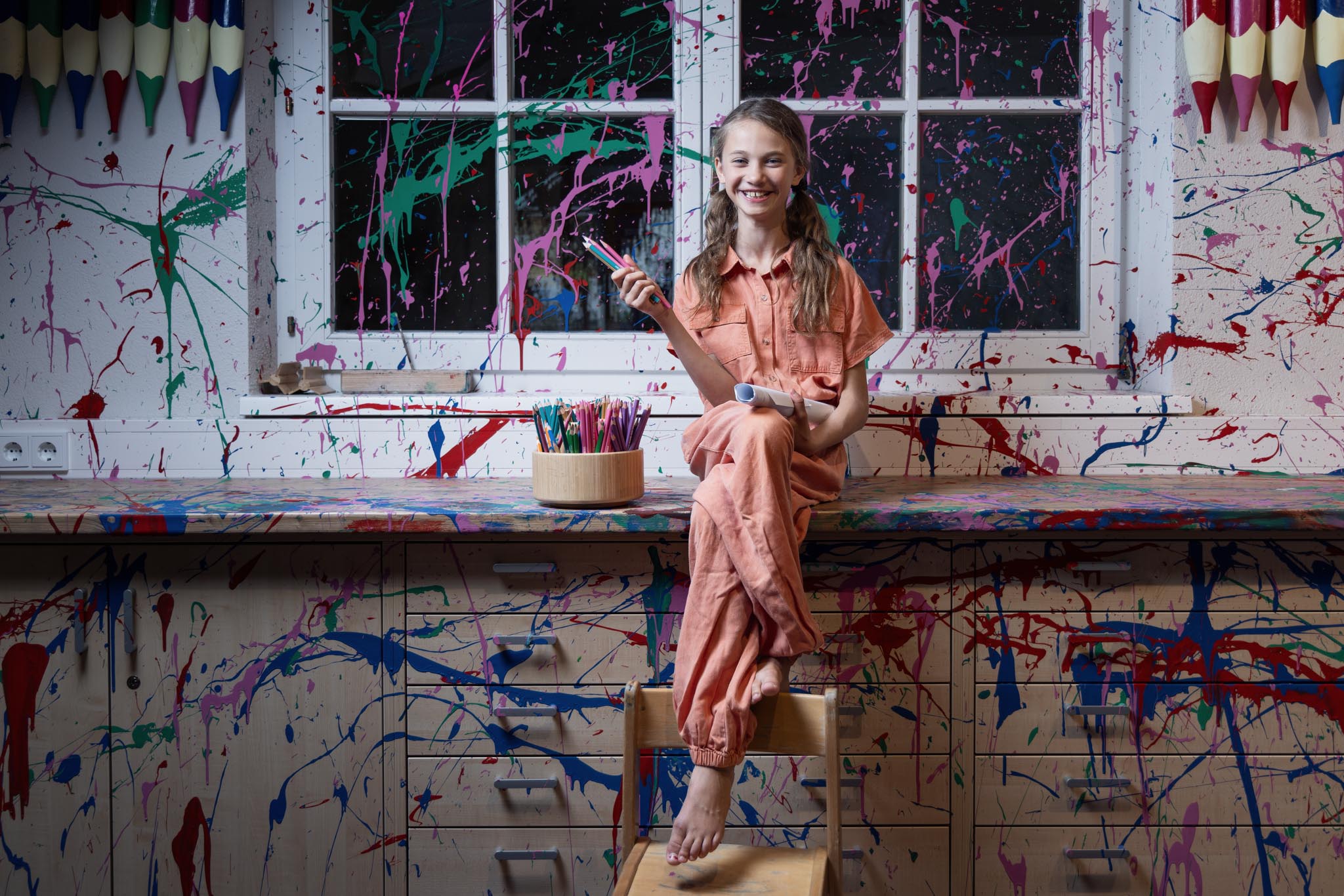 Teenie Mädchen sitzt in einem Creative Studio im Kids Club des Alpenrose Familux Resorts.