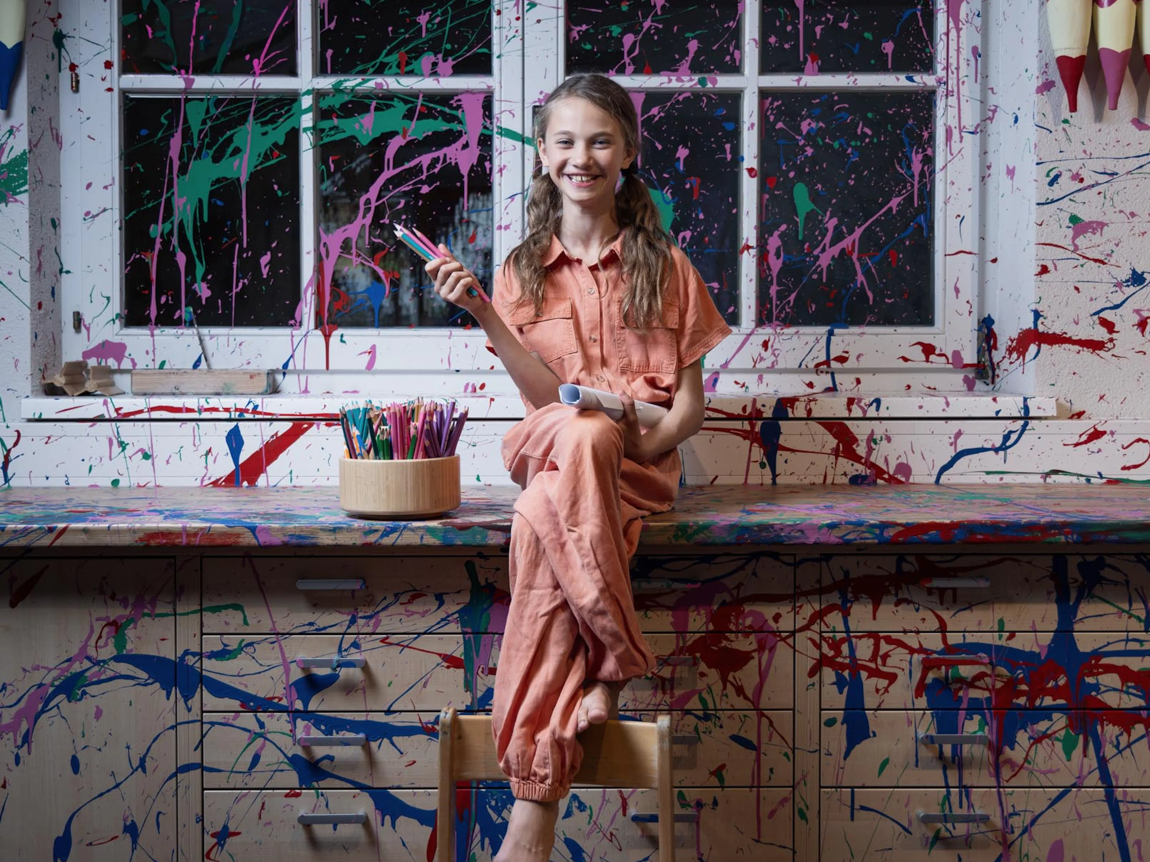 Teenie Mädchen sitzt in einem Creative Studio im Kids Club des Alpenrose Familux Resorts.