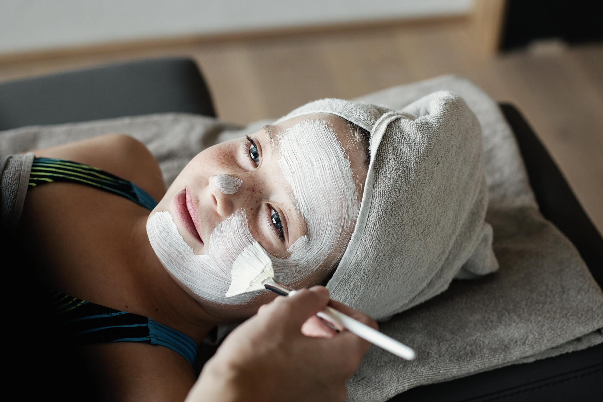 Mädchen bekommt eine Gesichtsmaske im Spa eines Familux Resorts.