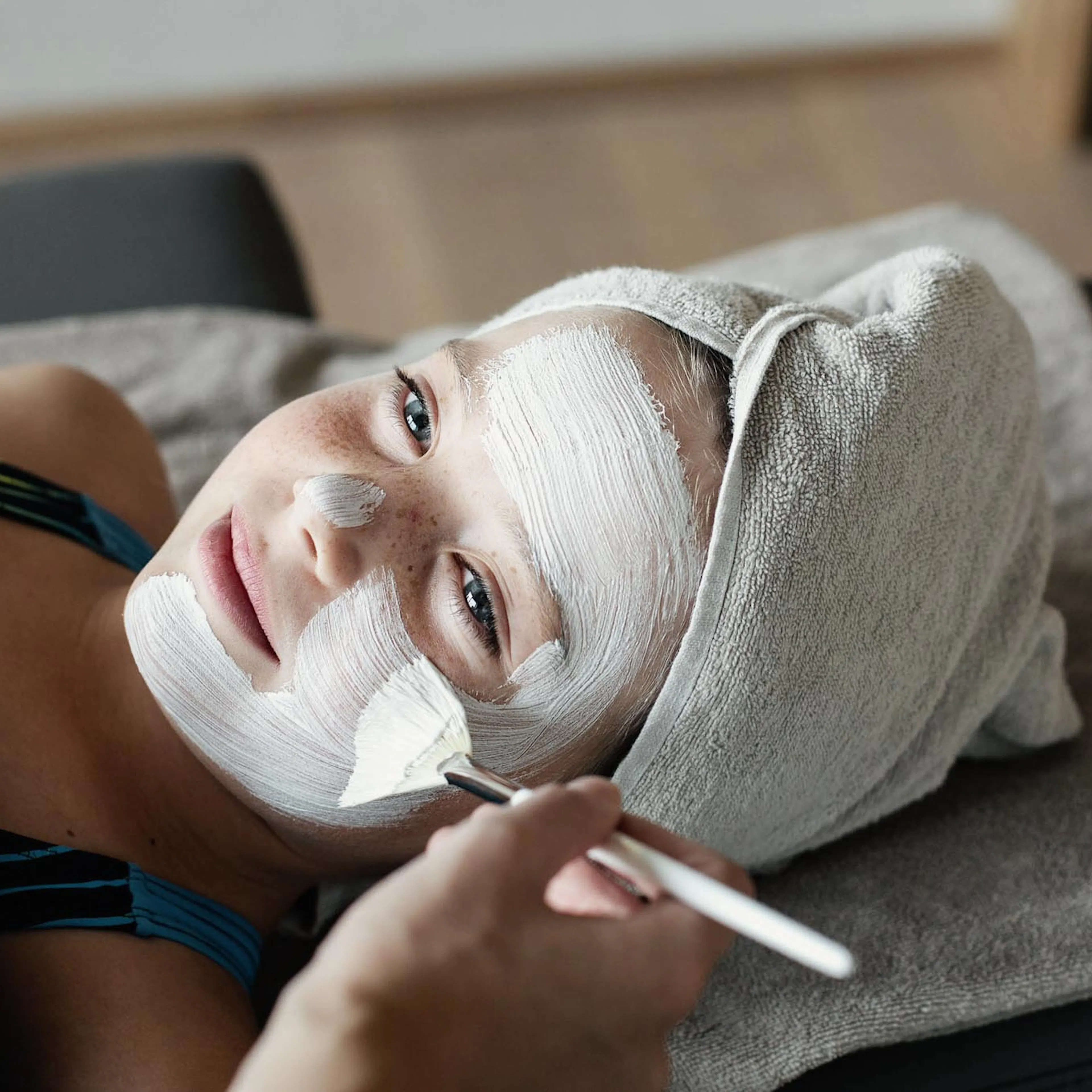 Mädchen bekommt eine Gesichtsmaske im Spa eines Familux Resorts.