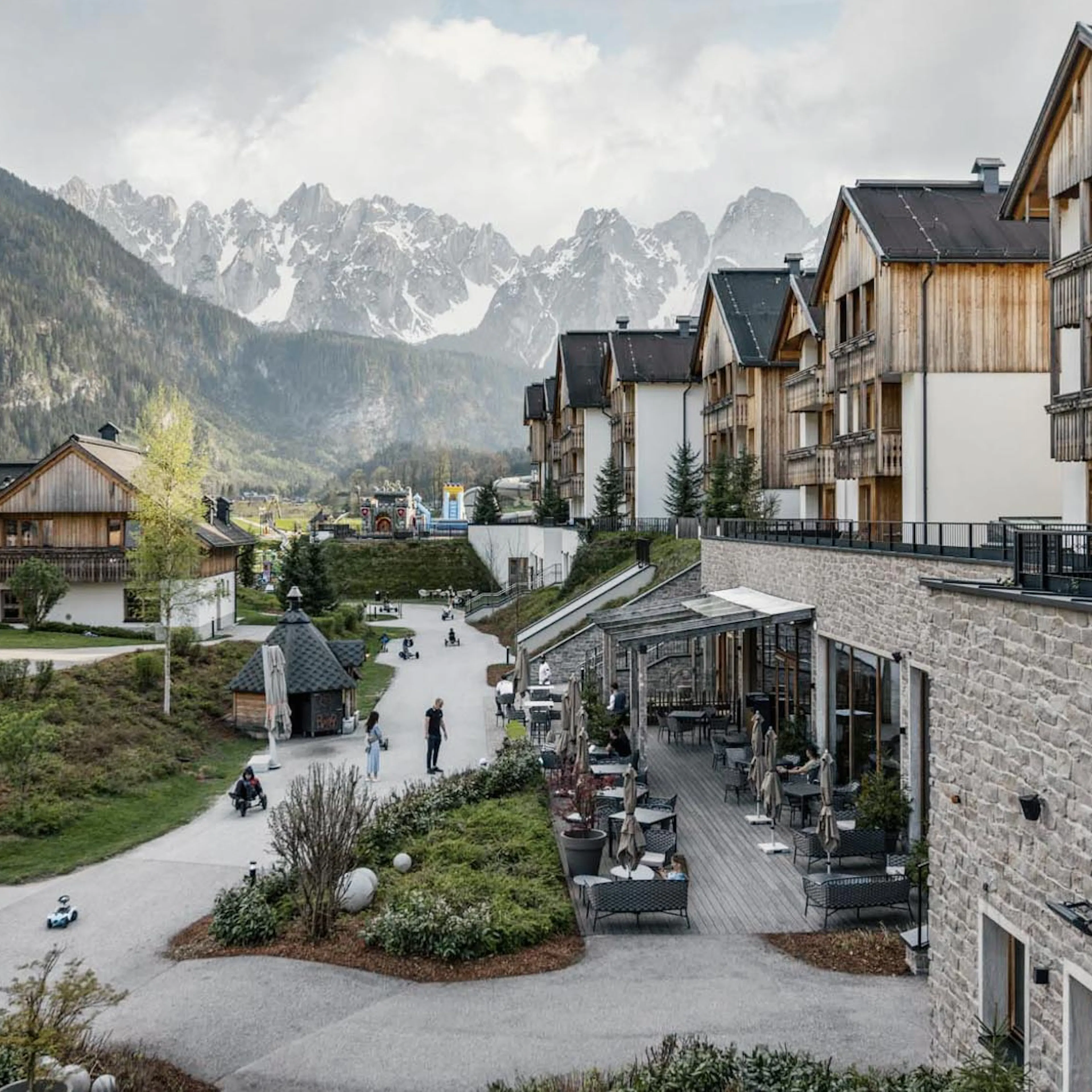 Exterior view of the Dachsteinkönig – Familux Resort with views of the mountains and chalets.