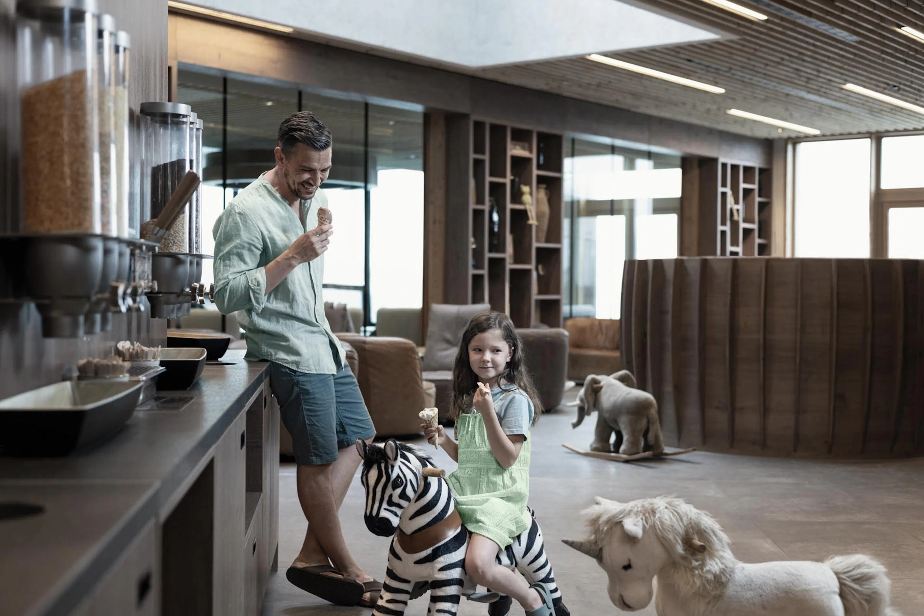 Father and child enjoying a soft-serve ice cream in the restaurant at The Grand Green – Familux Resort.