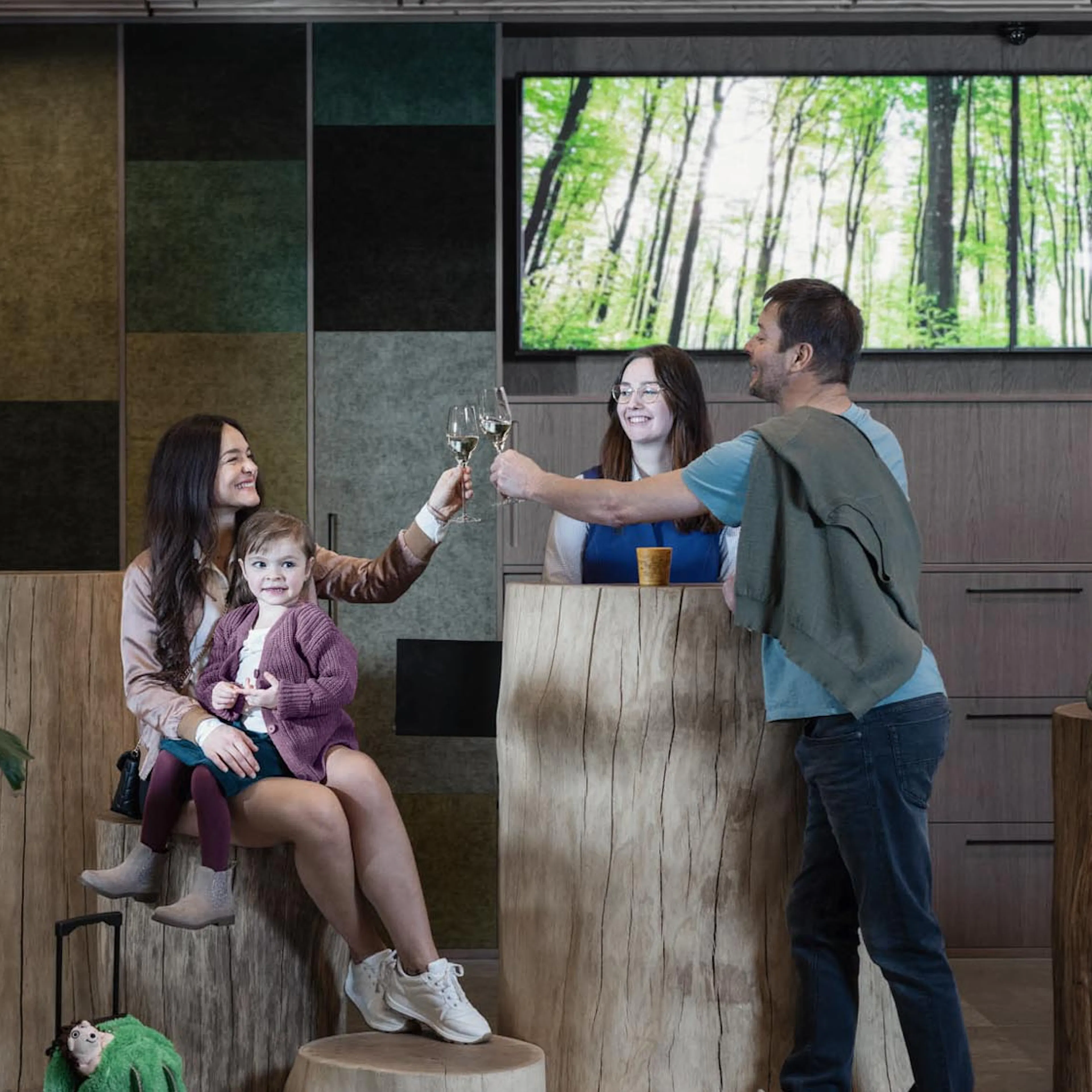 Family checking in with a member of staff at The Grand Green – Familux Resort whilst enjoying a glass of sparkling wine.