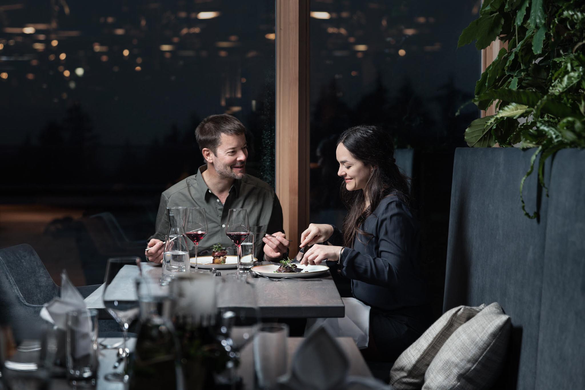 Eltern essen zu Abend im Restaurant des The Grand Green - Familux Resorts.