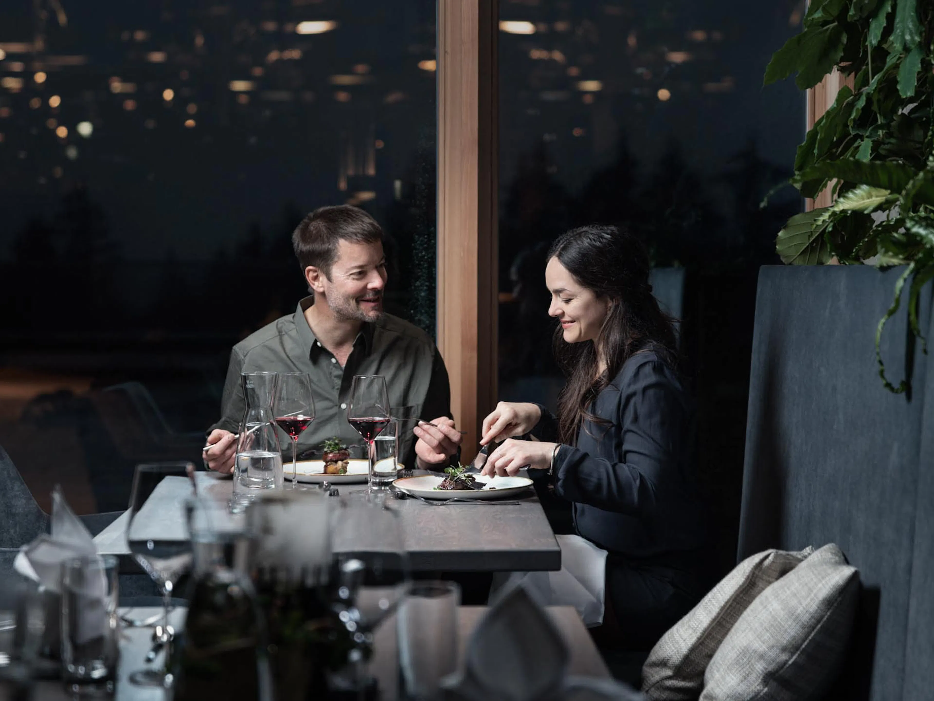 Eltern essen zu Abend im Restaurant des The Grand Green - Familux Resorts.