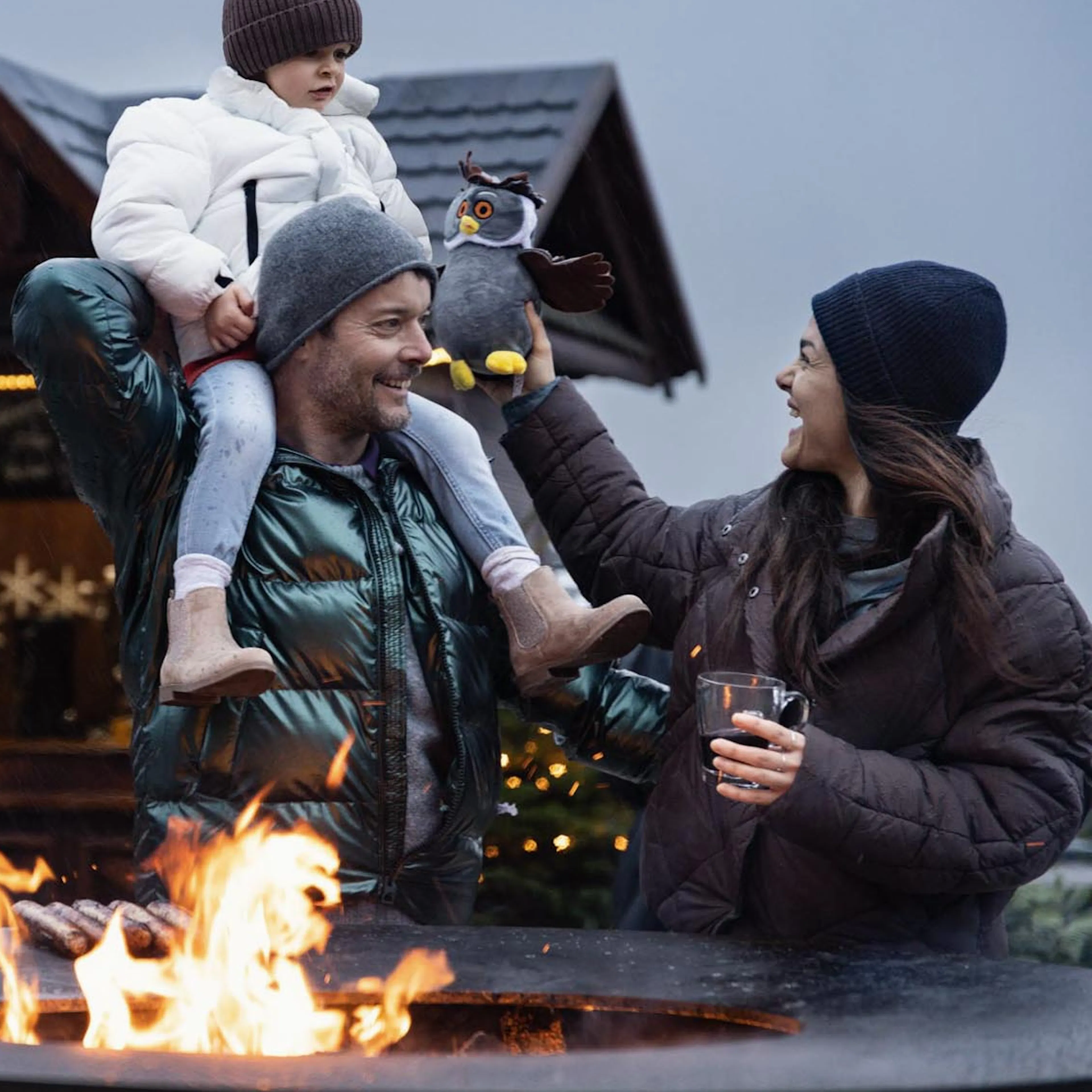 Family standing at the Ofyr grill in winter on the terrace of The Grand Green – Familux Resort.