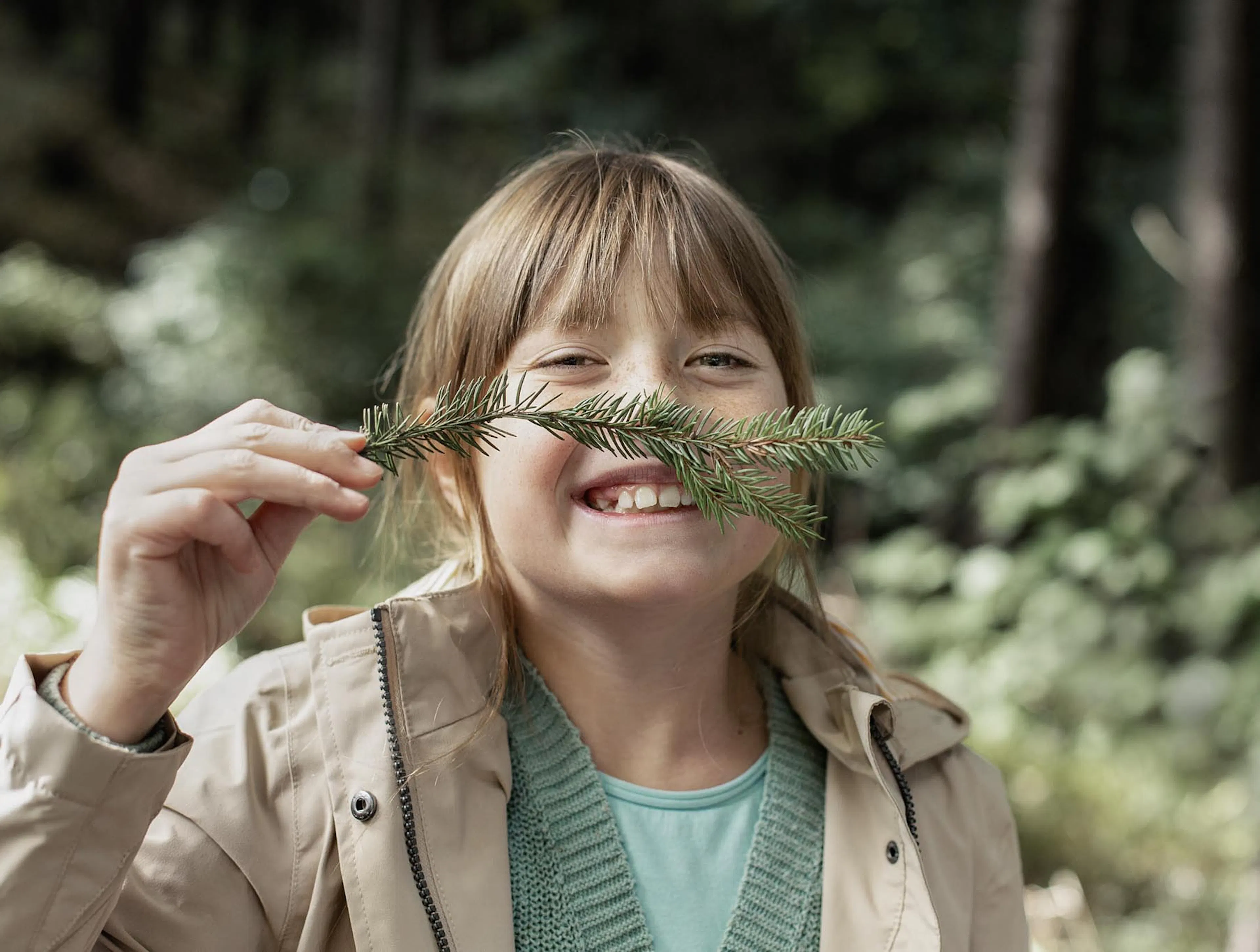 Girl playing with twigs in the forest in autumn.