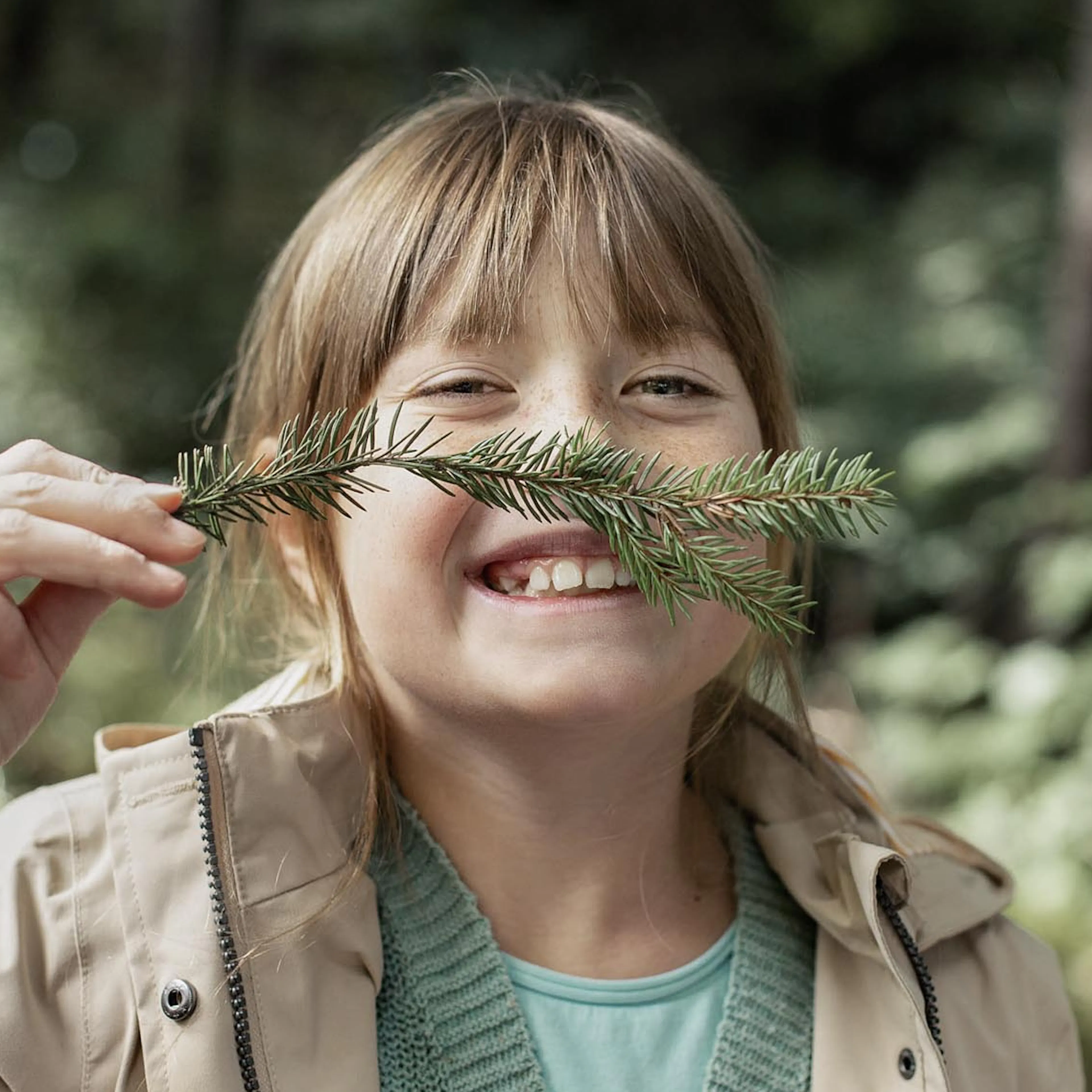 Girl playing with twigs in the forest in autumn.