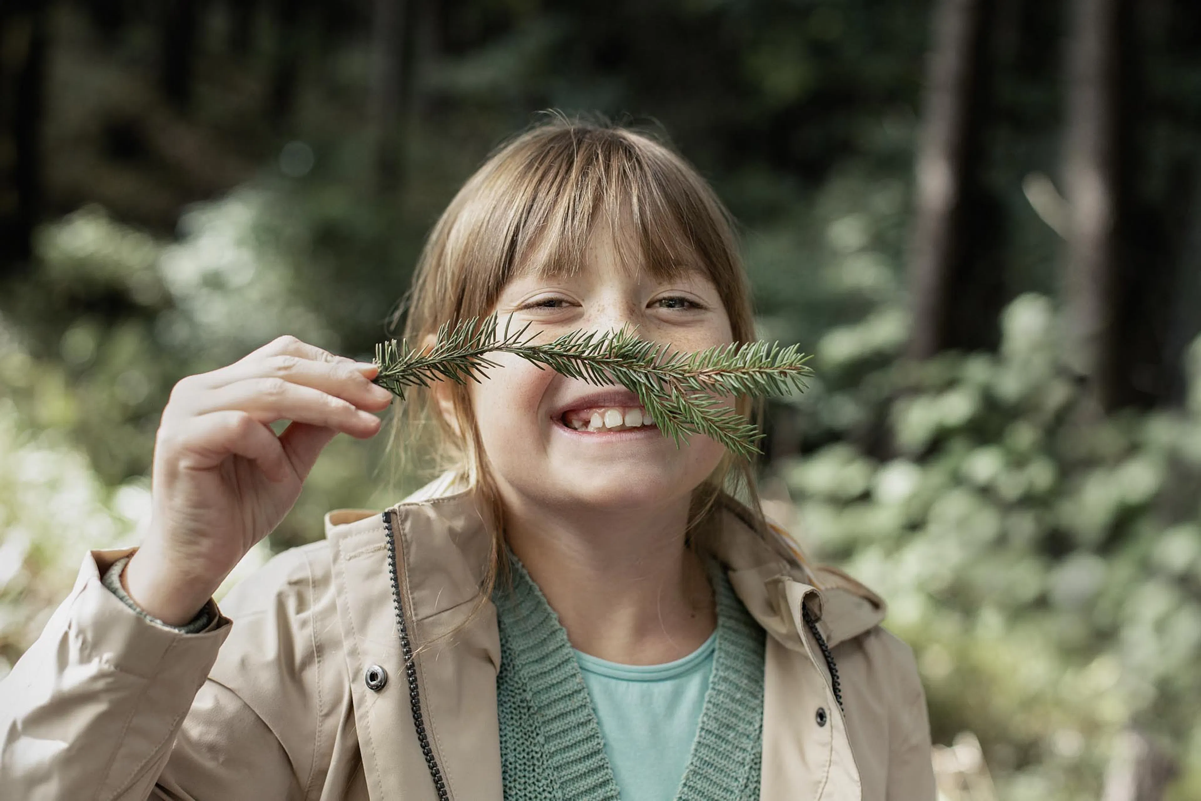 Girl playing with twigs in the forest in autumn.