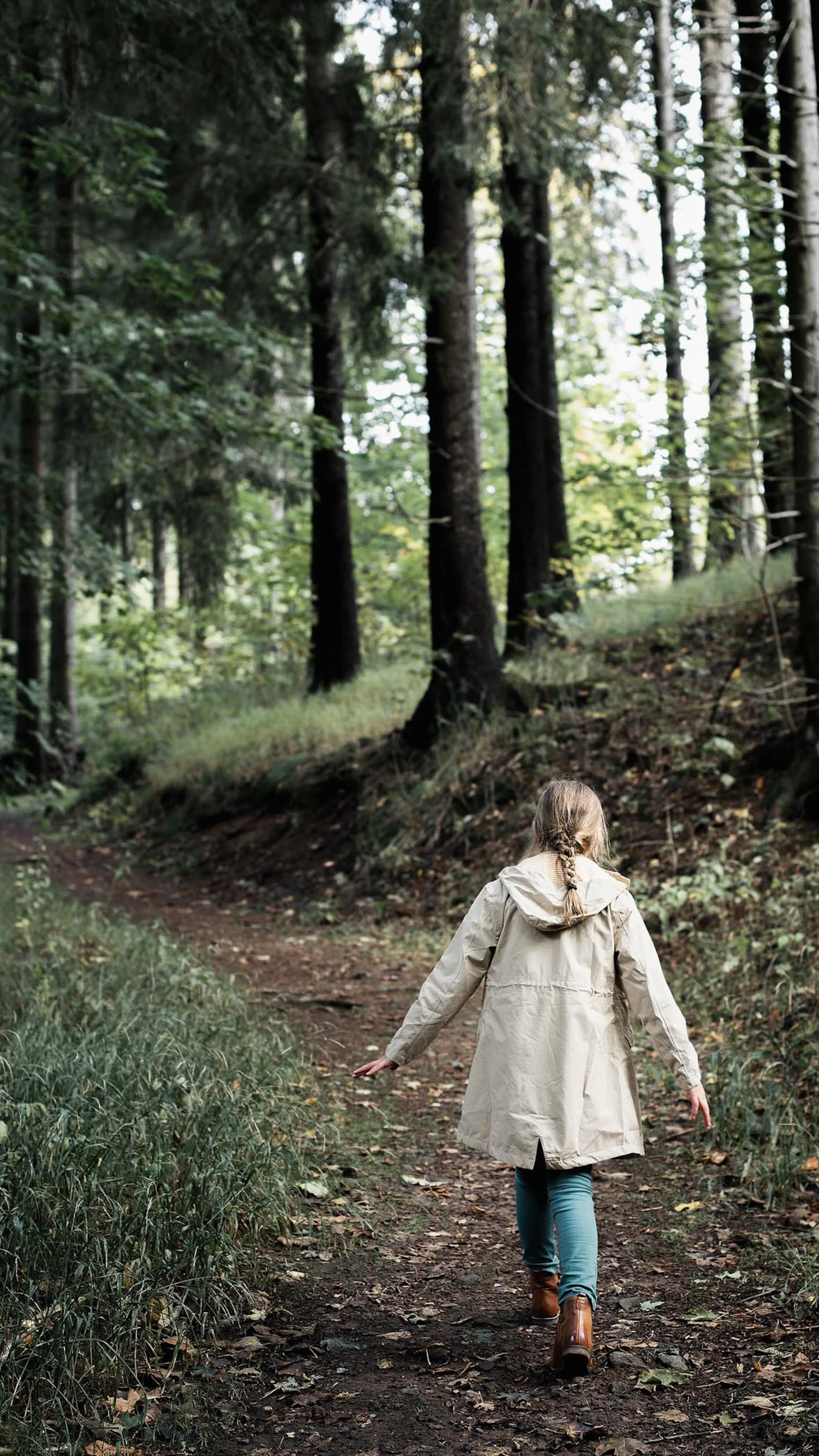 Mädchen geht im Wald im Herbst spazieren.