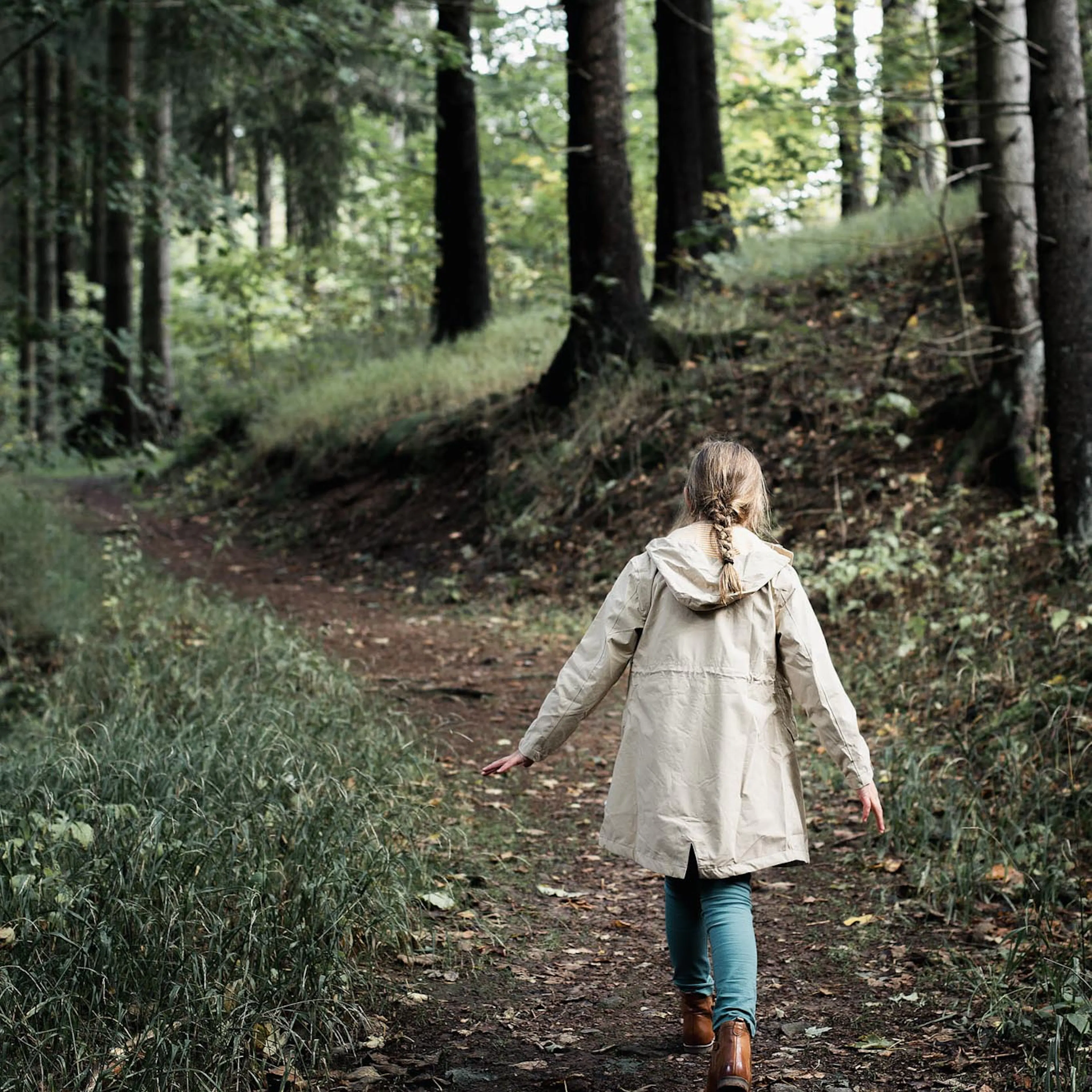 Mädchen geht im Wald im Herbst spazieren.