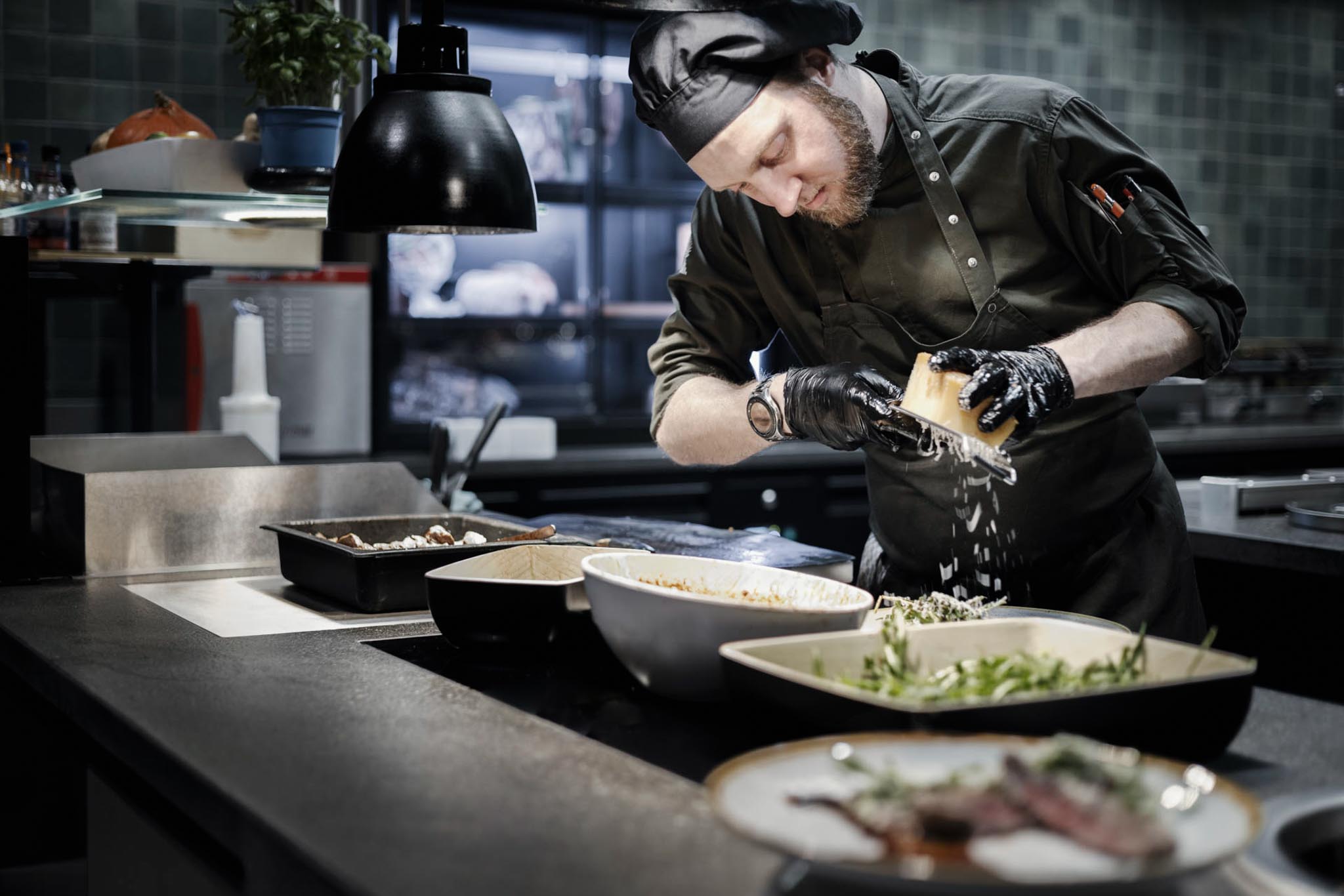 Koch bereitet ein Gericht an der Live-Cooking Station des The Grand Green - Familux Resorts zu.