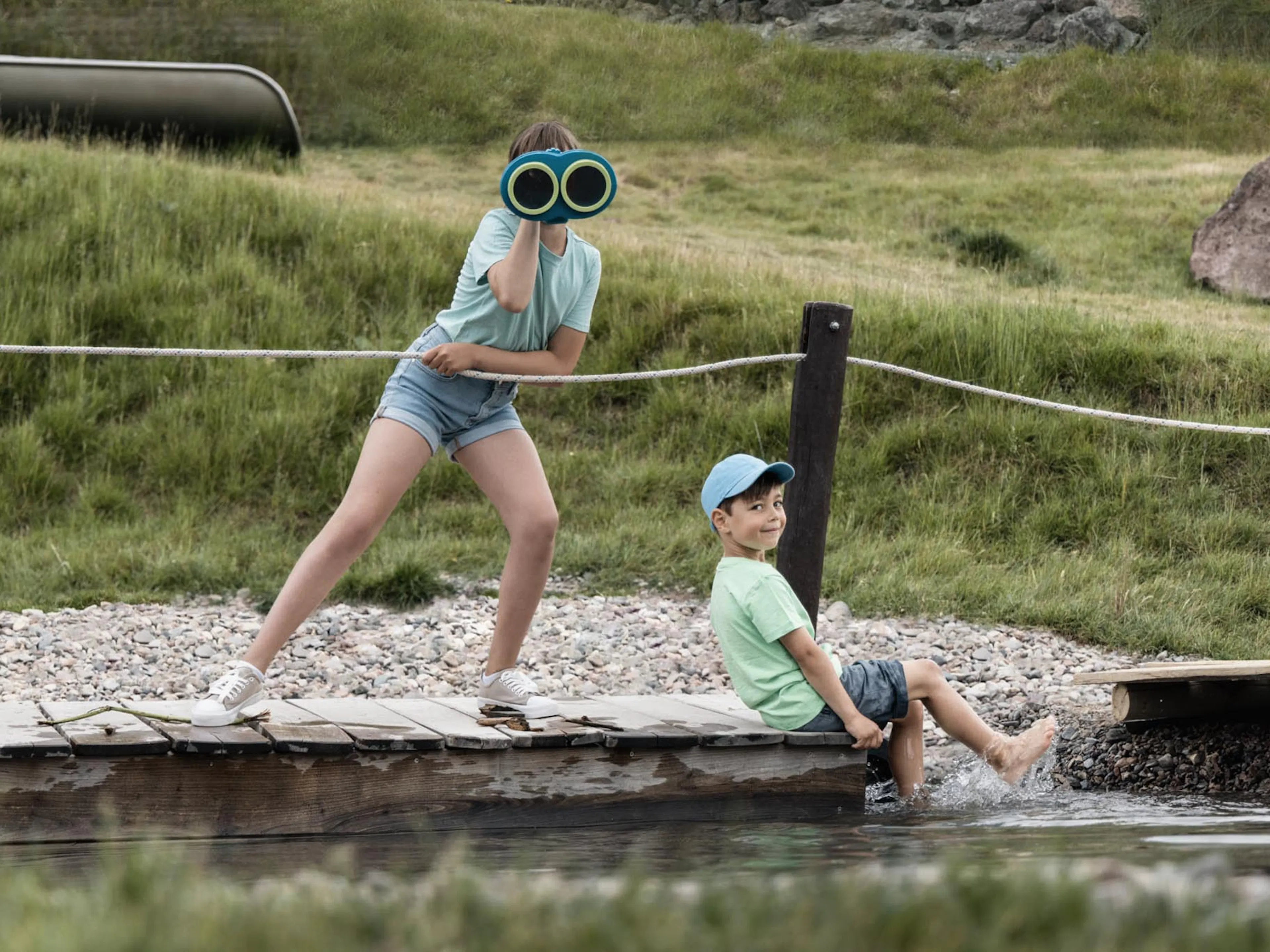 Girl and boy playing on the raft on the playground at The Grand Green – Familux Resort.