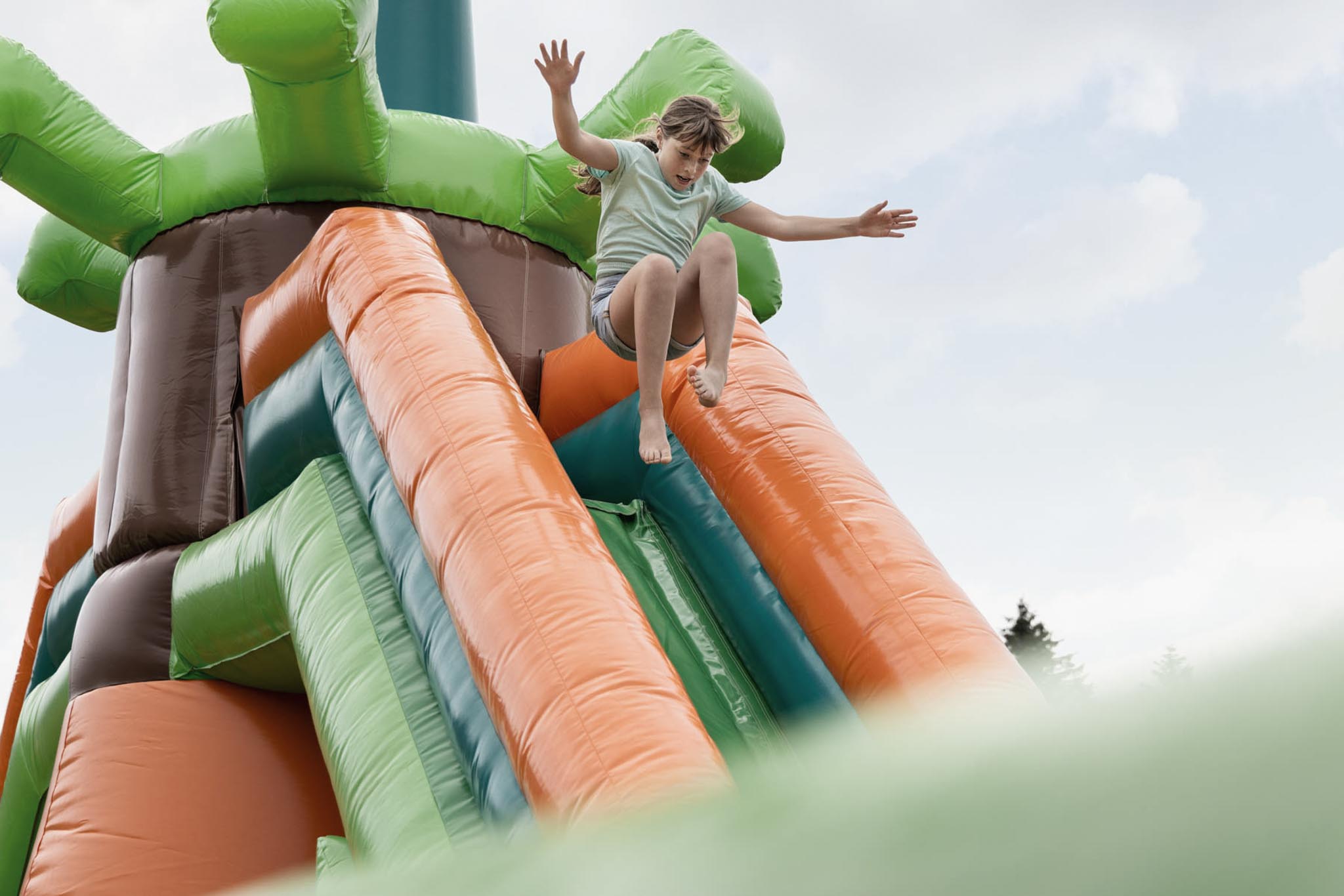 Girl bouncing on a bouncy castle in the hotel gardens of The Grand Green – Familux Resort.