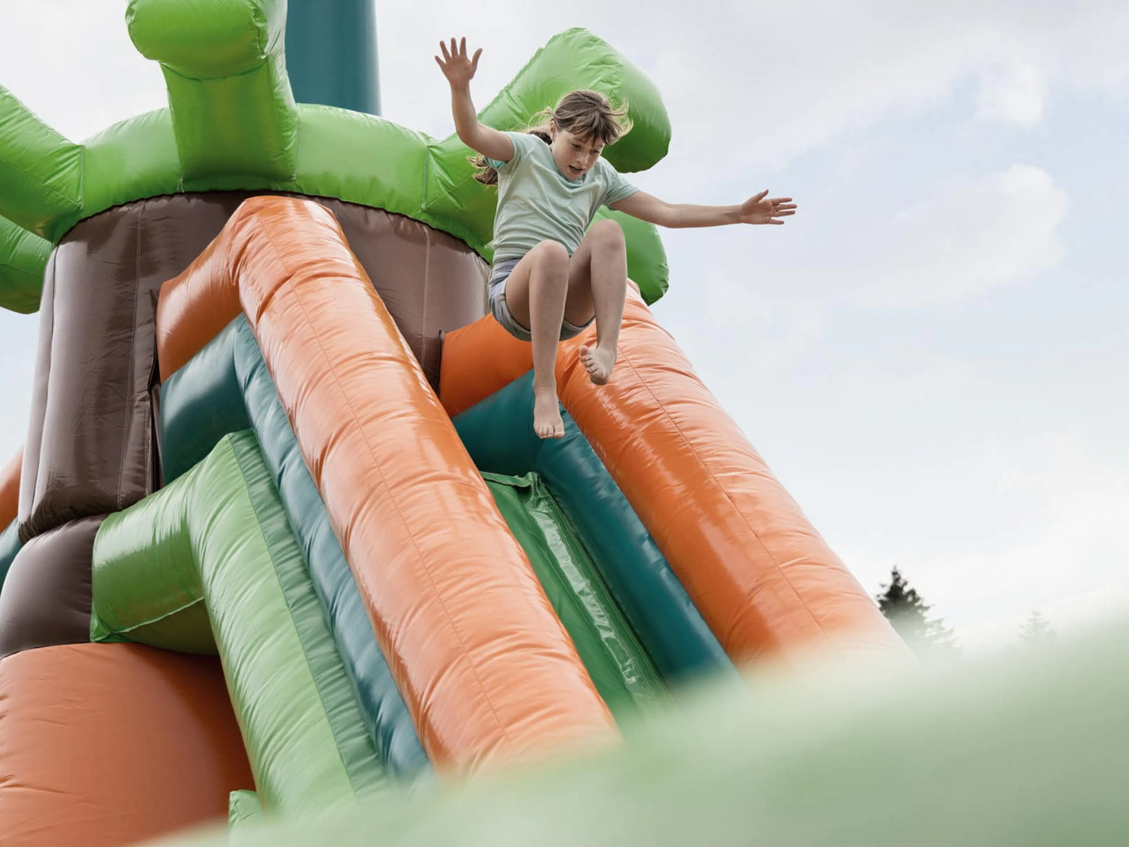 Girl bouncing on a bouncy castle in the hotel gardens of The Grand Green – Familux Resort.