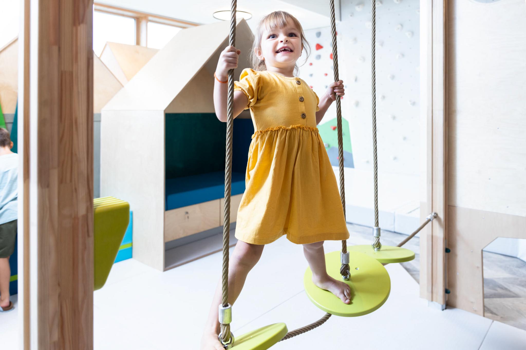 Girl climbing on the climbing tower in the Kids Club at The Grand Green – Familux Resort.