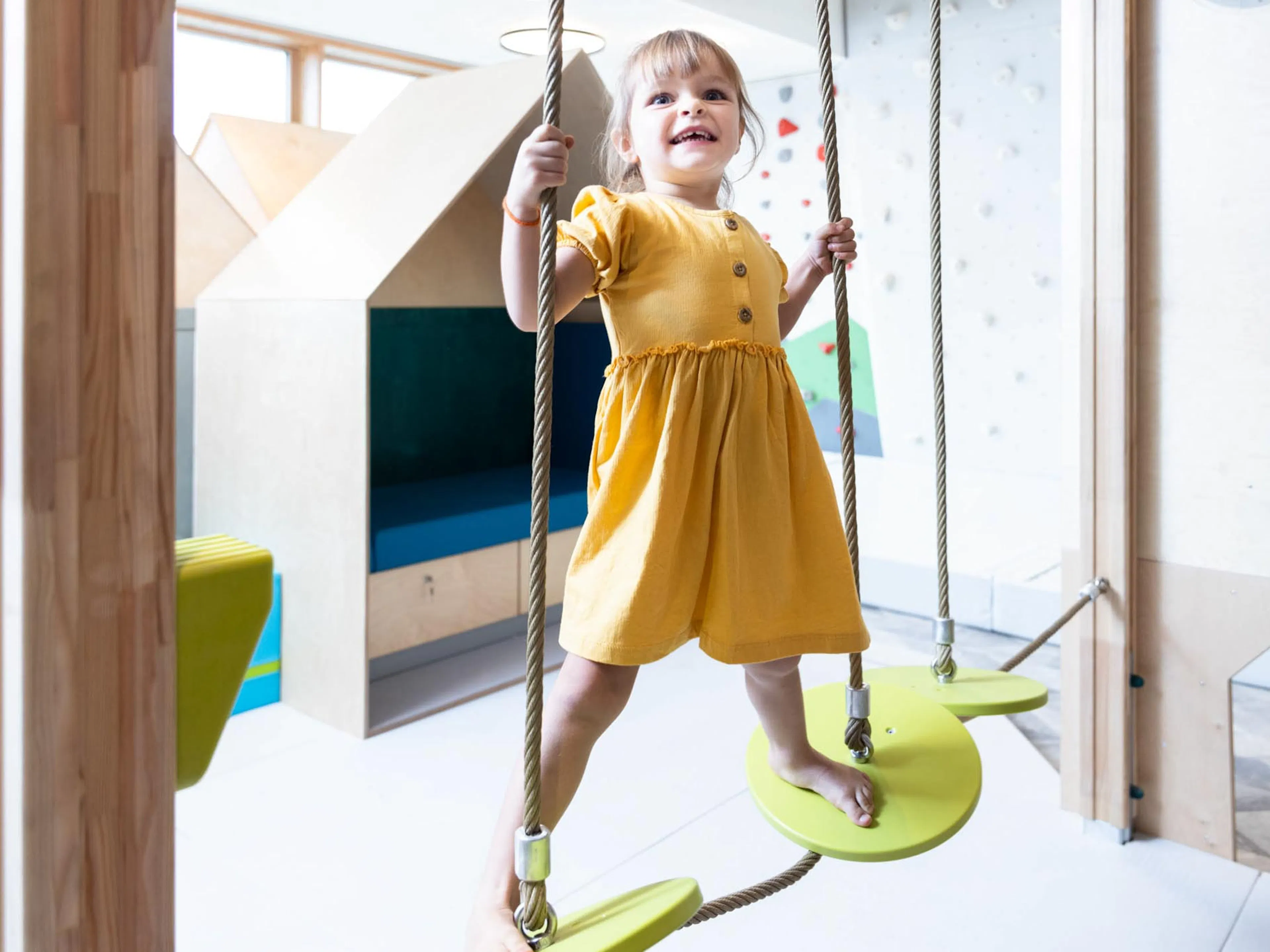 Girl climbing on the climbing tower in the Kids Club at The Grand Green – Familux Resort.