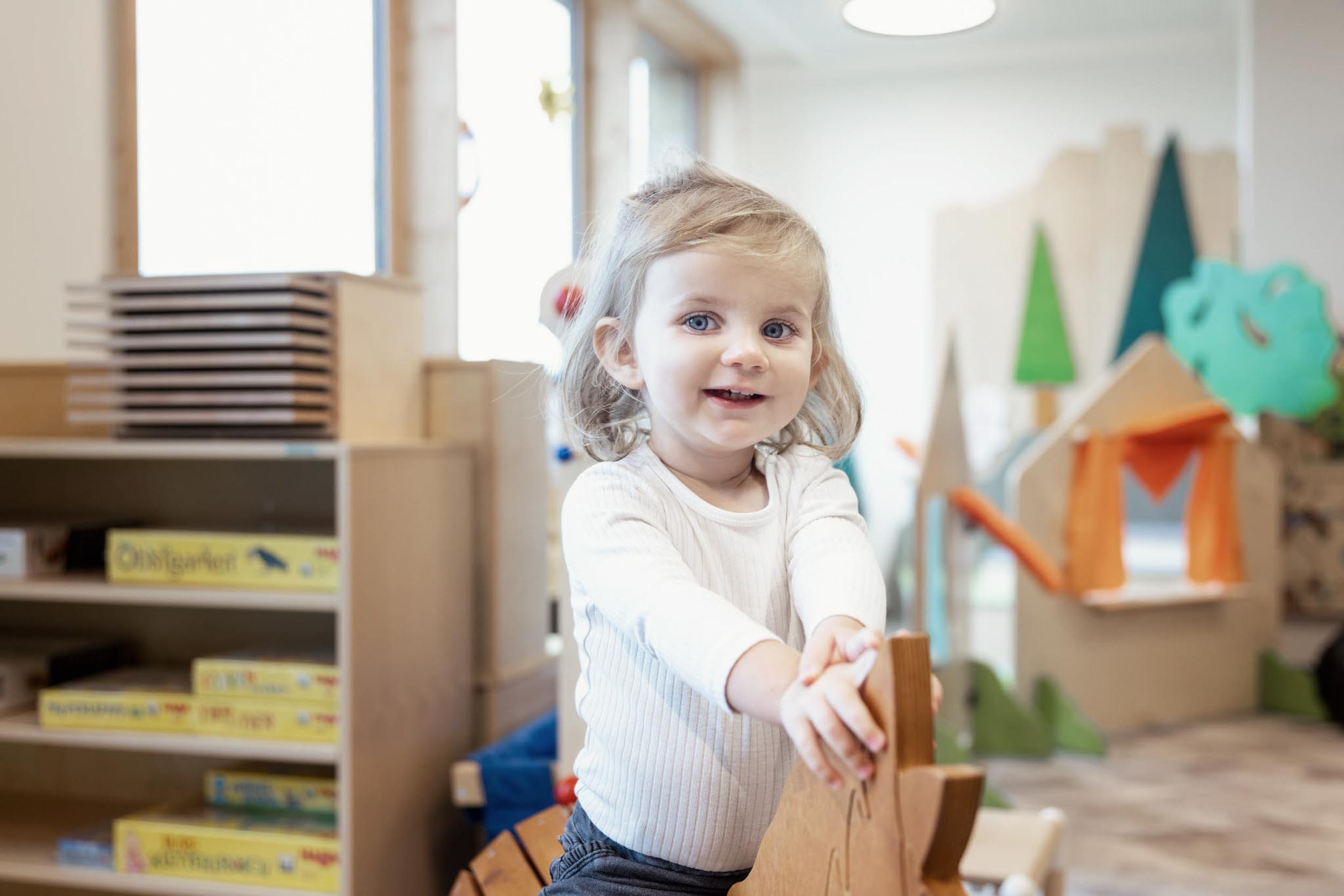 Girl on a rocking horse in the Kids Club at The Grand Green – Familux Resort.