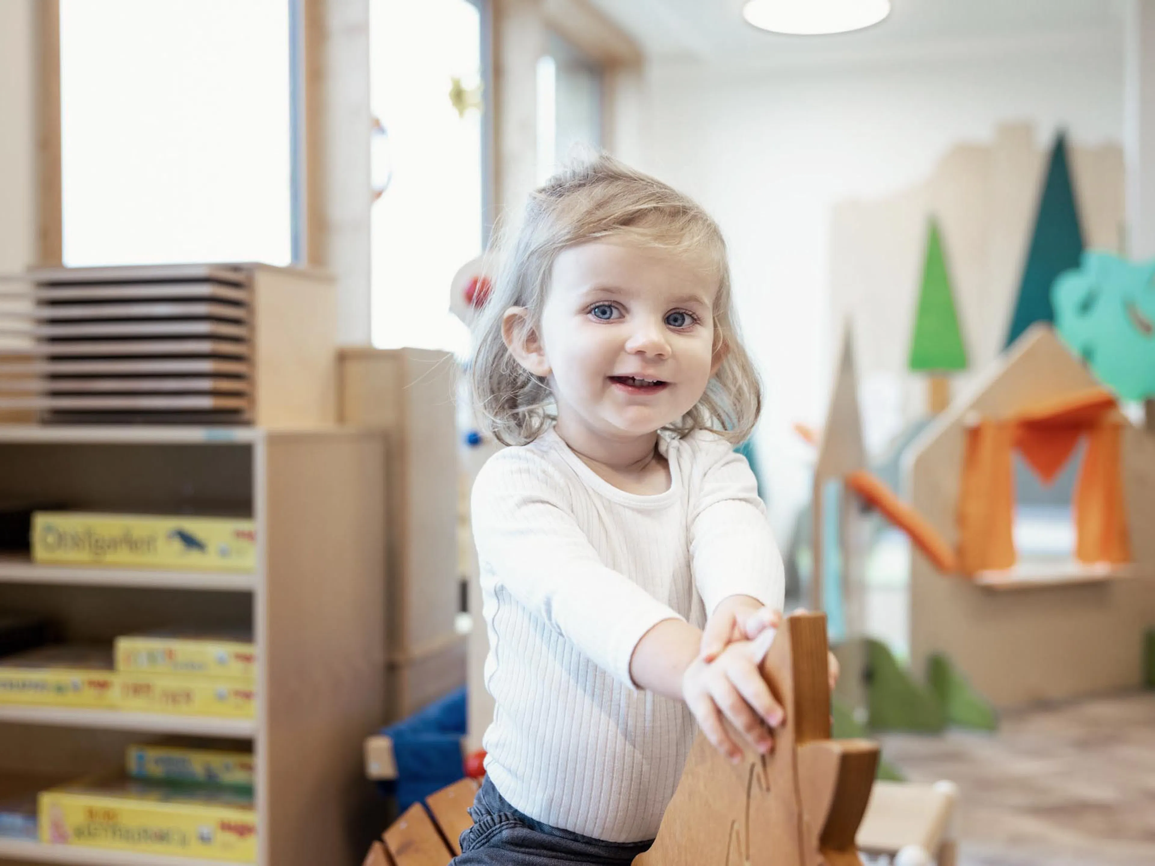 Girl on a rocking horse in the Kids Club at The Grand Green – Familux Resort.