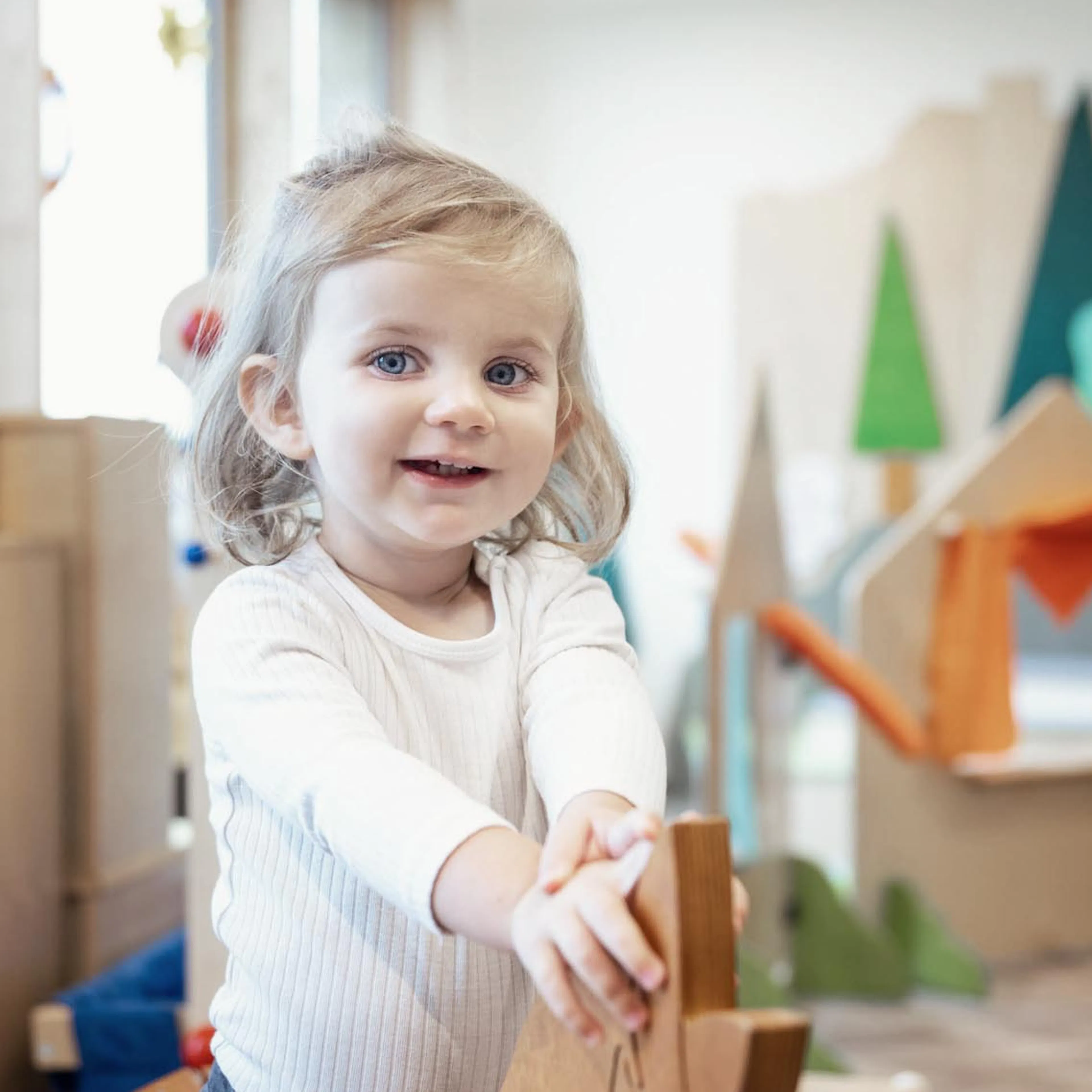 Girl on a rocking horse in the Kids Club at The Grand Green – Familux Resort.