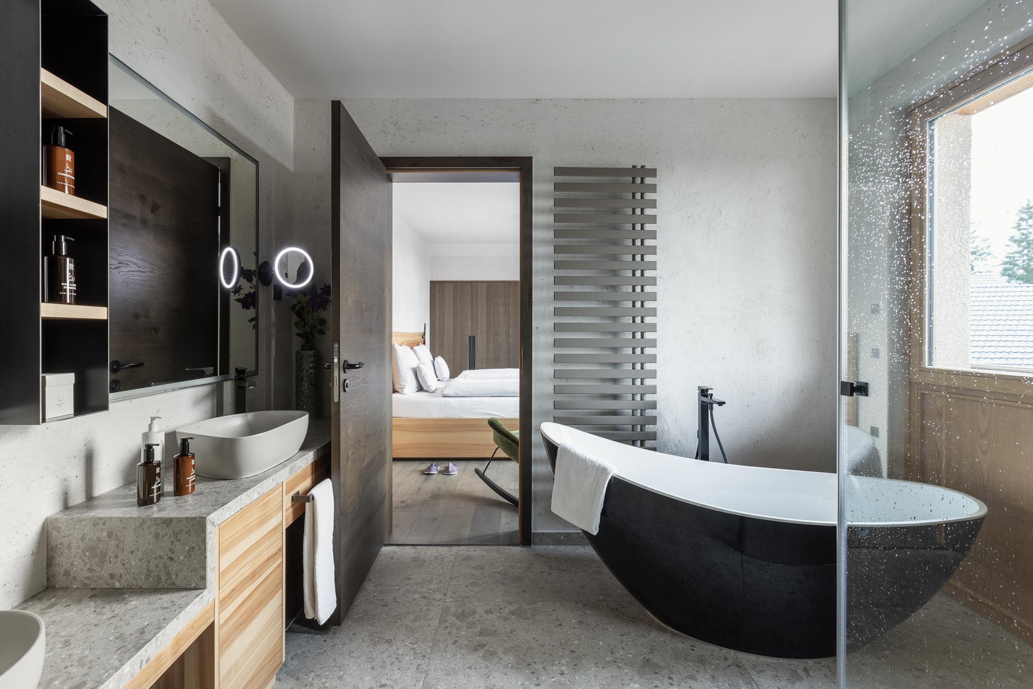 Bathroom with freestanding bath and views into the master bedroom of a chalet at The Grand Green – Familux Resort.