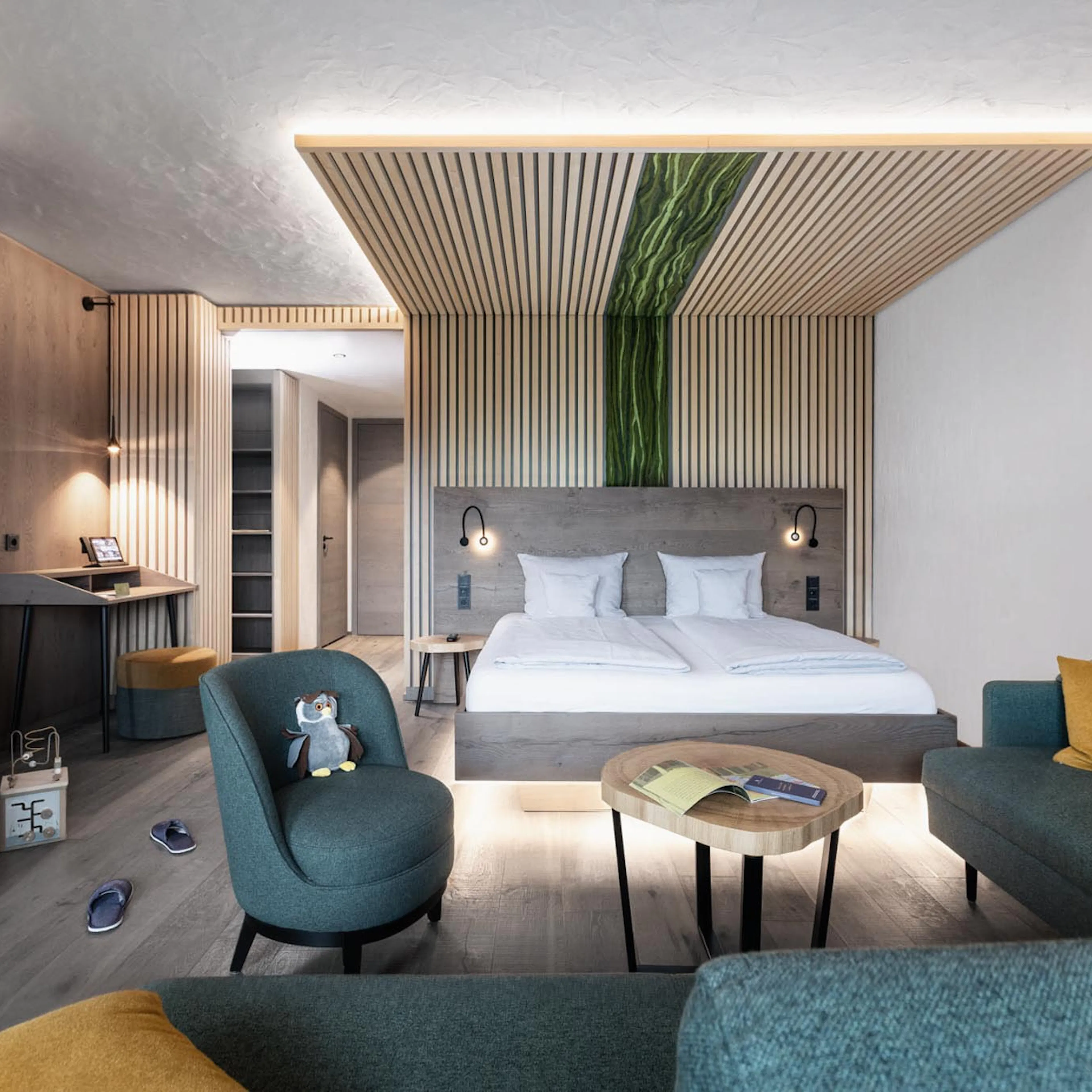 Familiensuite mit Bett und Sofalandschaft im The Grand Green - Familux Resort.