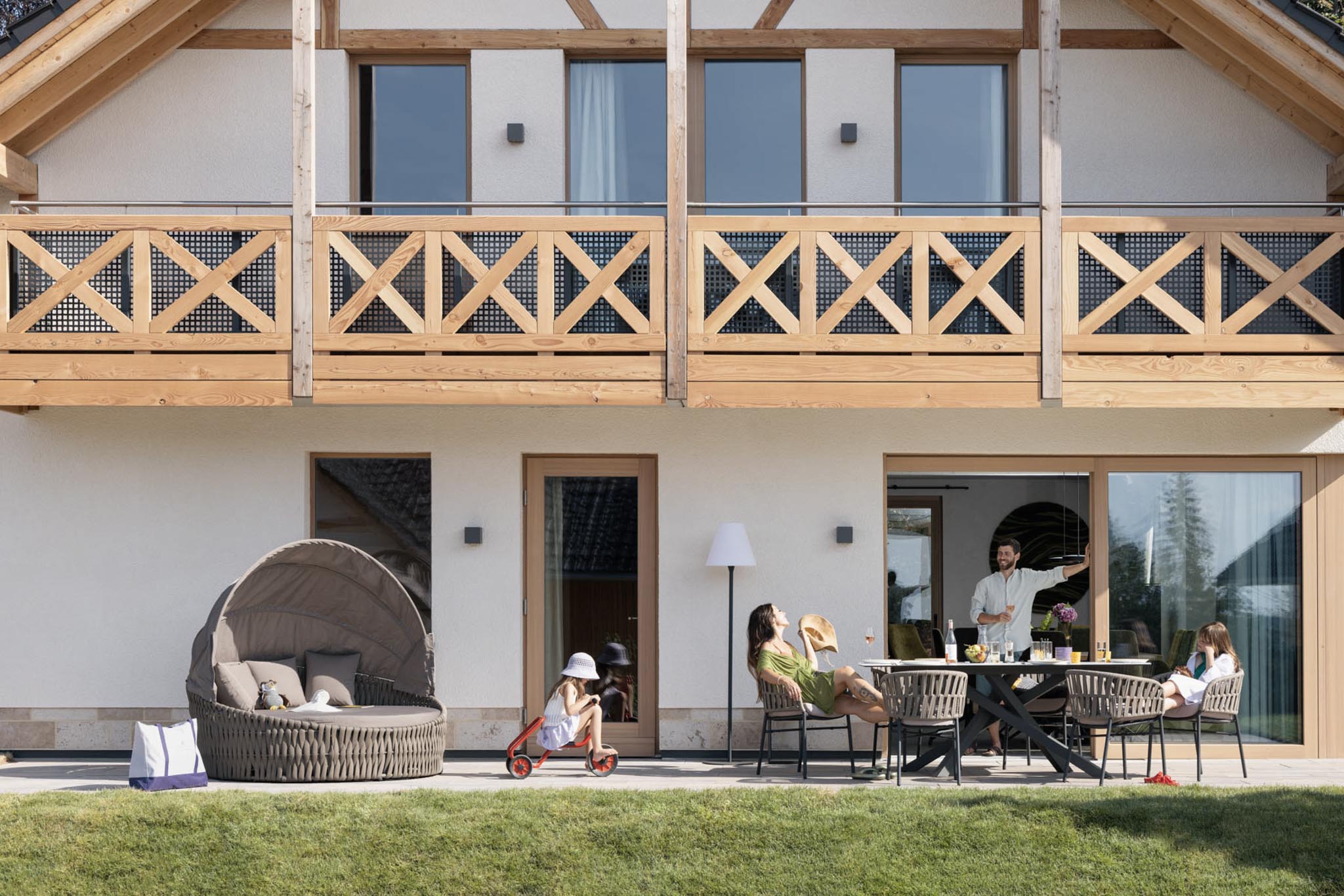 Family sitting on the terrace of a chalet at The Grand Green – Familux Resort.