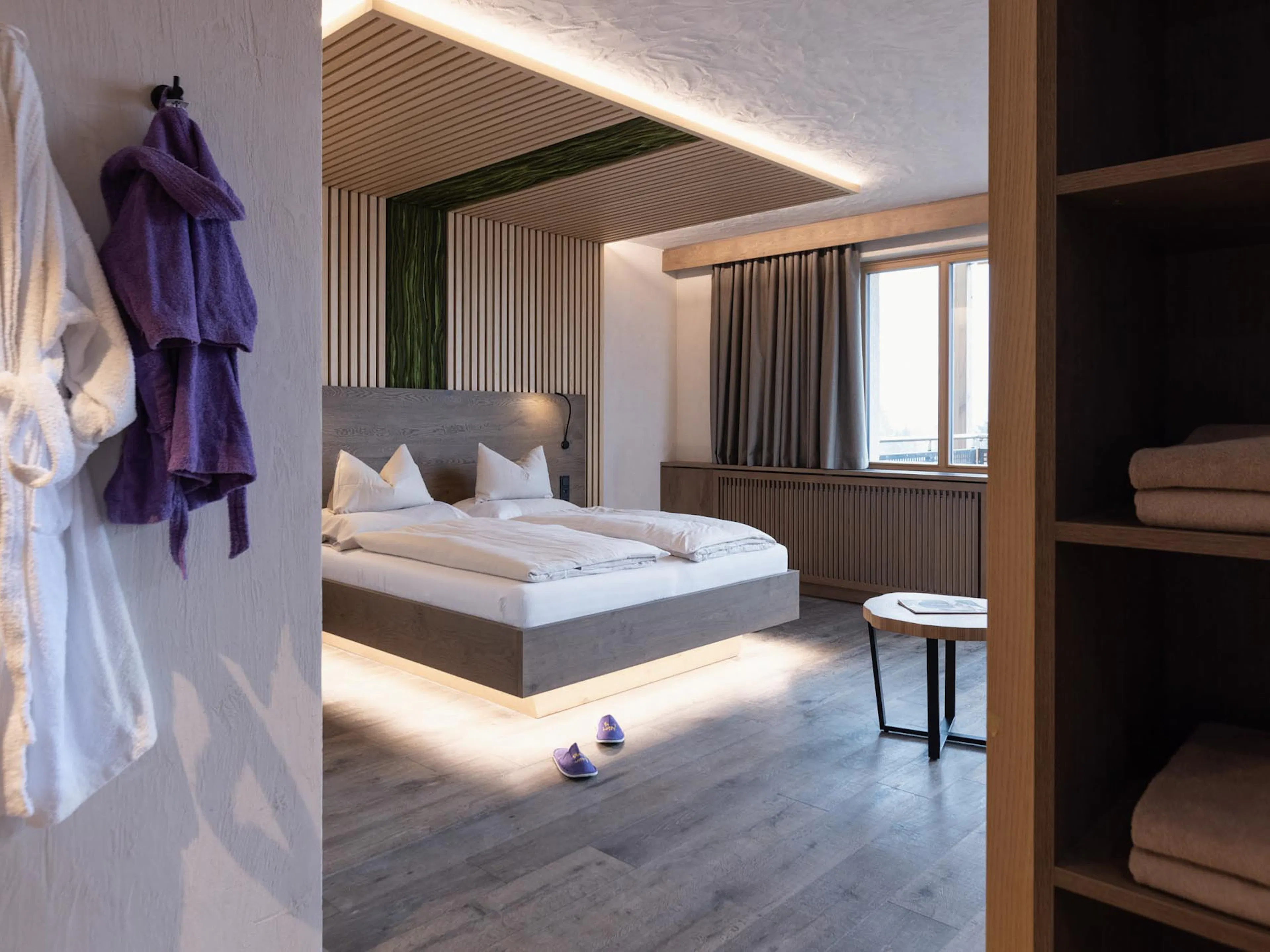 Familiensuite mit Bett und Bademänteln im The Grand Green - Familux Resort.