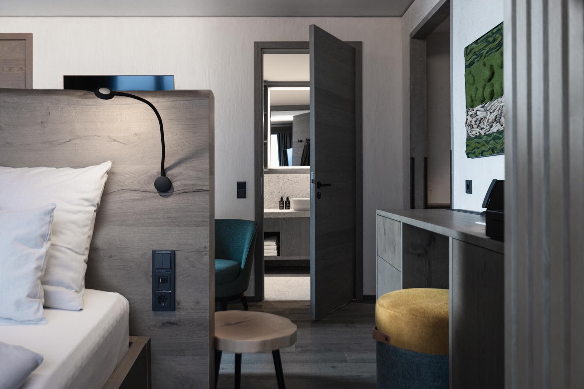 Family suite with bed, desk and views into the bathroom at The Grand Green – Familux Resort.