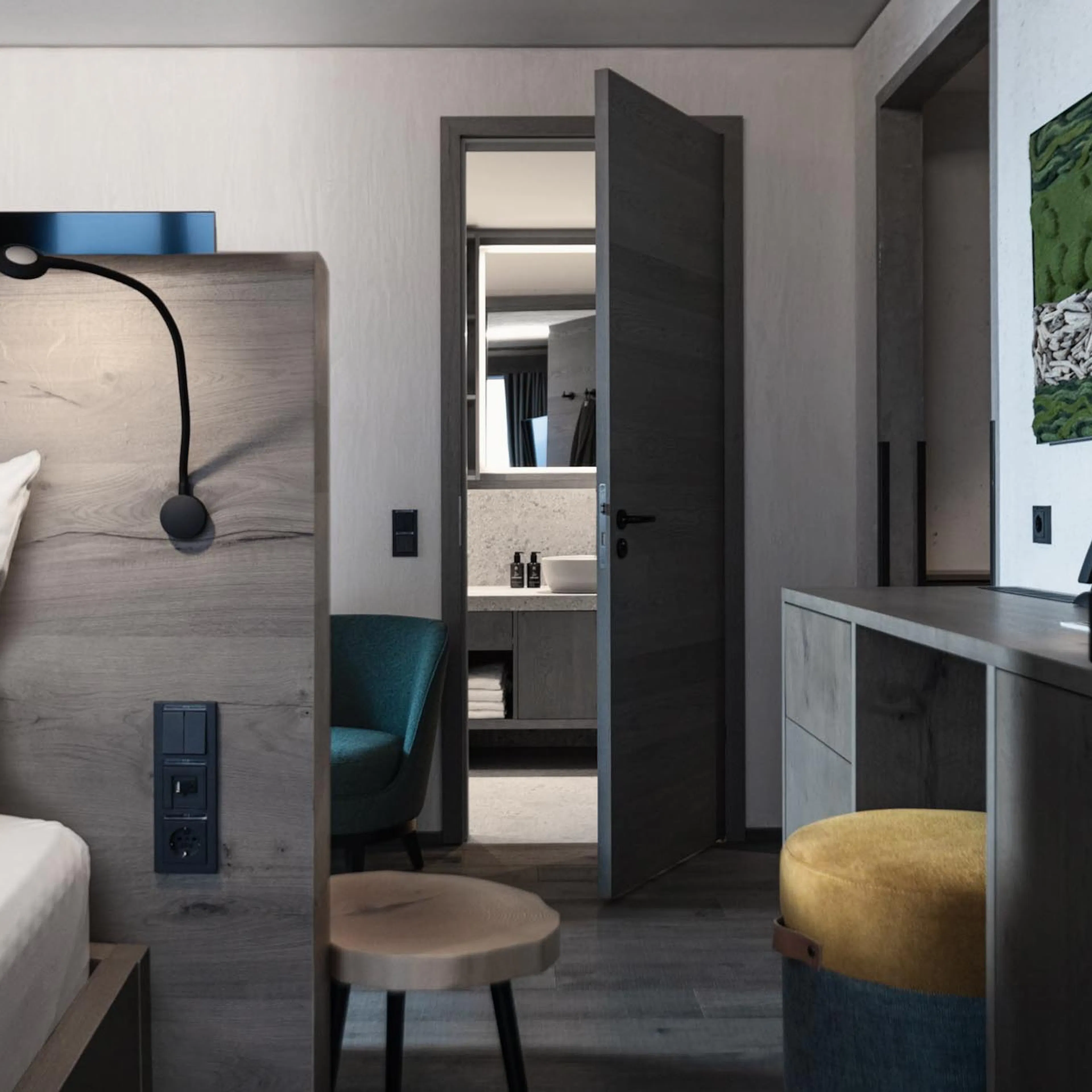 Familiensuite mit Bett, Schreibtisch und Blick ins Badezimmer im The Grand Green - Familux Resort.