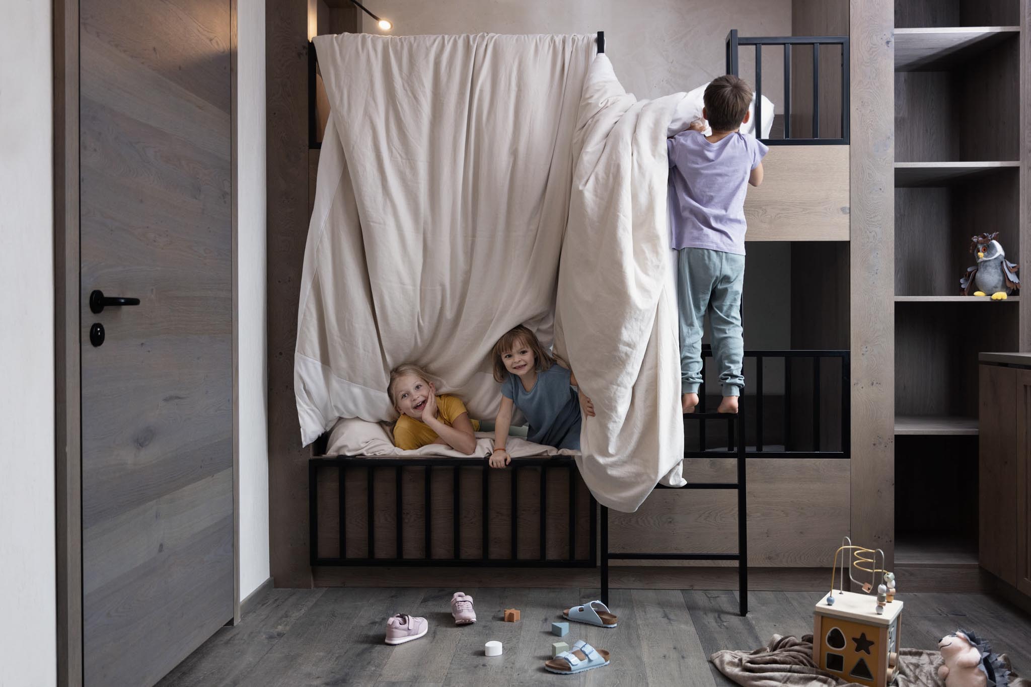 Children playing in the children's room of a family suite at The Grand Green – Familux Resort.