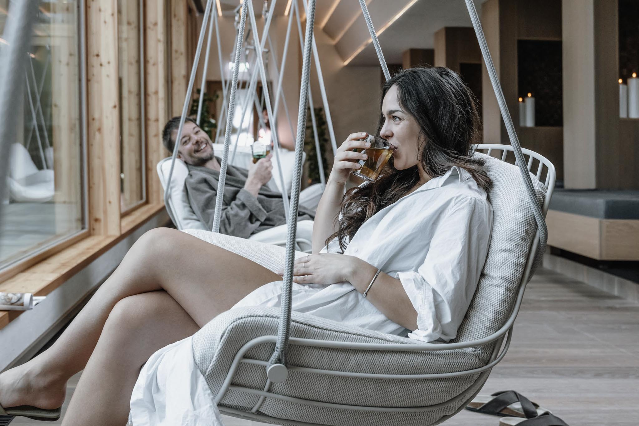 Parents relaxing in hanging chairs in the rest area of The Grand Green – Familux Resort.