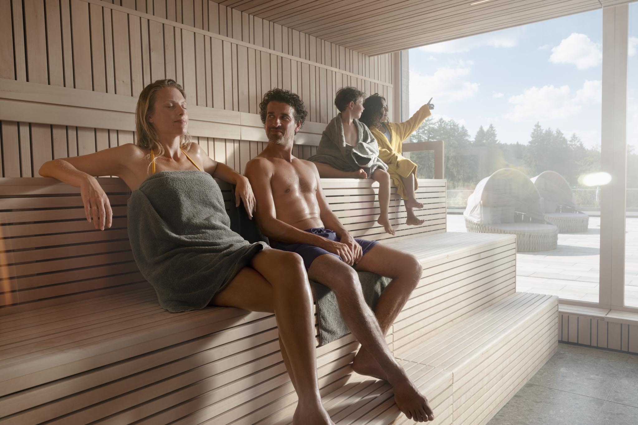 Family sauna with family and children in the pool area of The Grand Green – Familux Resort.