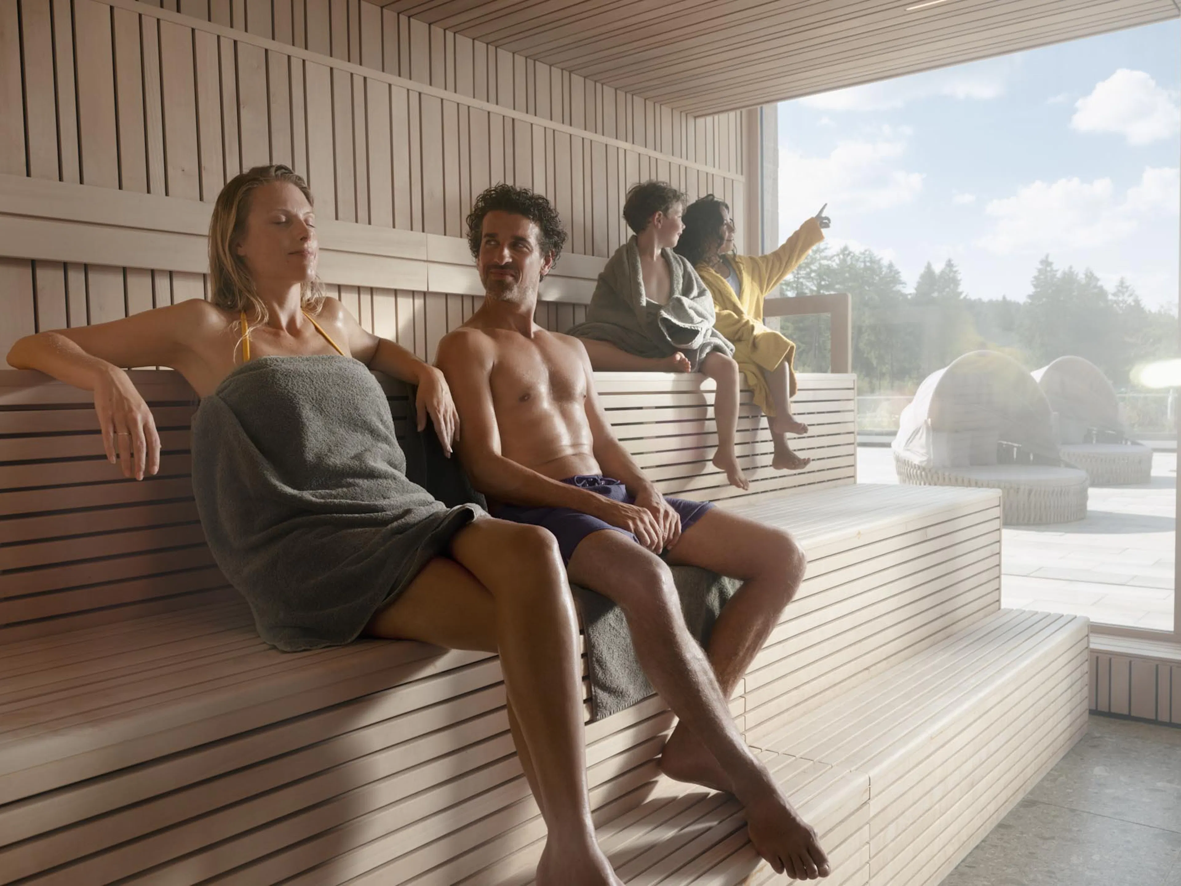 Family sauna with family and children in the pool area of The Grand Green – Familux Resort.