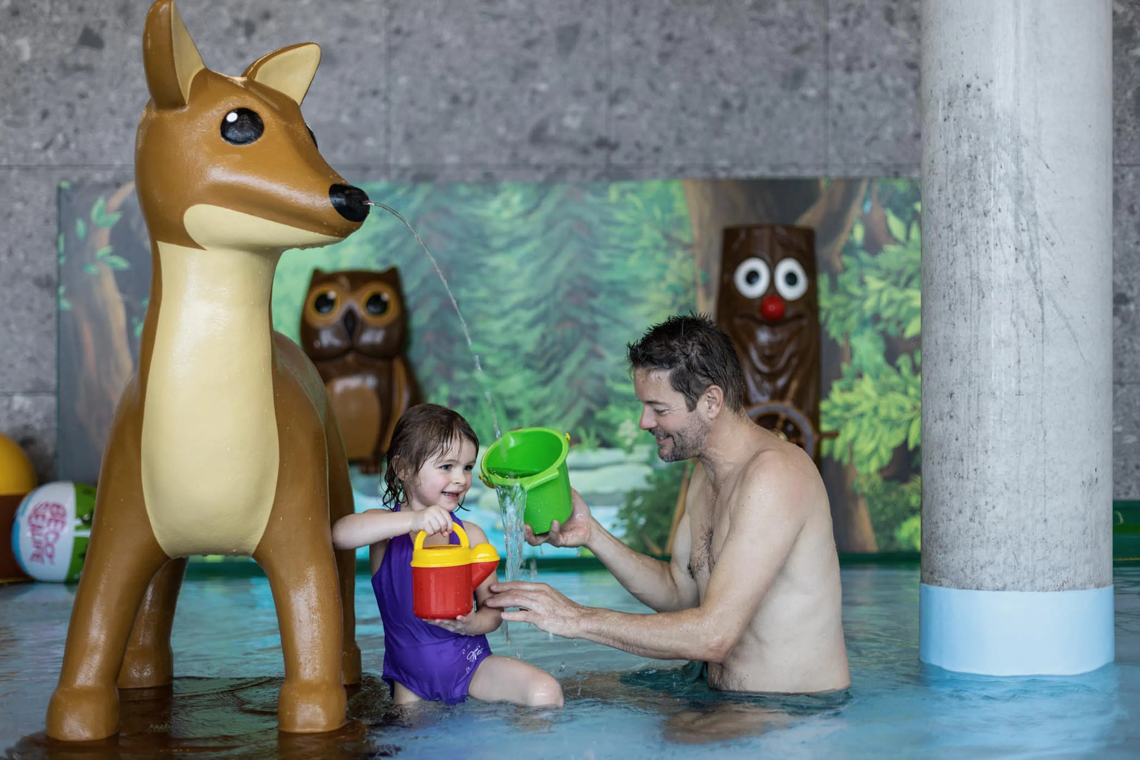 Father playing with his daughter in the baby pool at The Grand Green – Familux Resort.