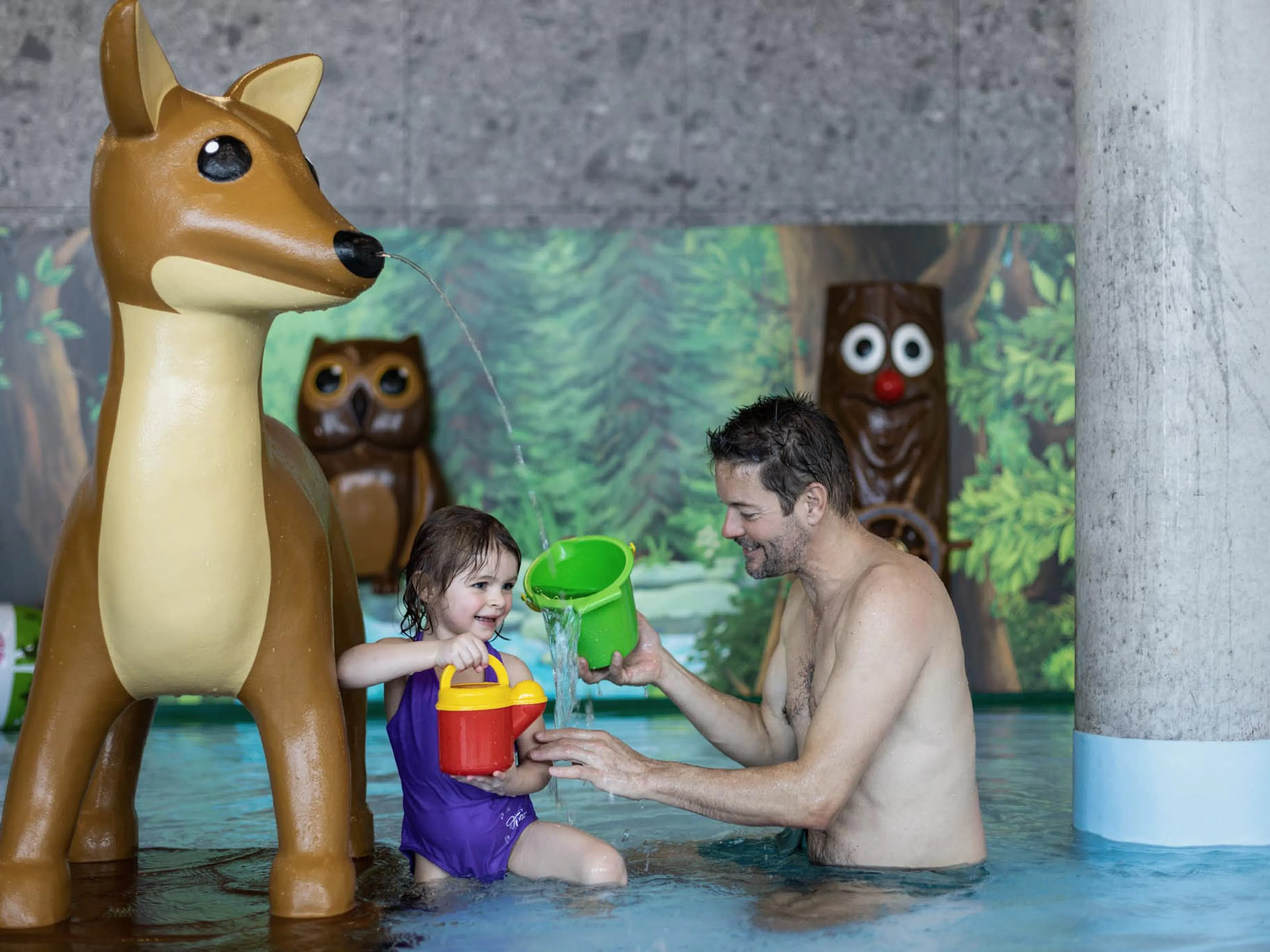 Father playing with his daughter in the baby pool at The Grand Green – Familux Resort.