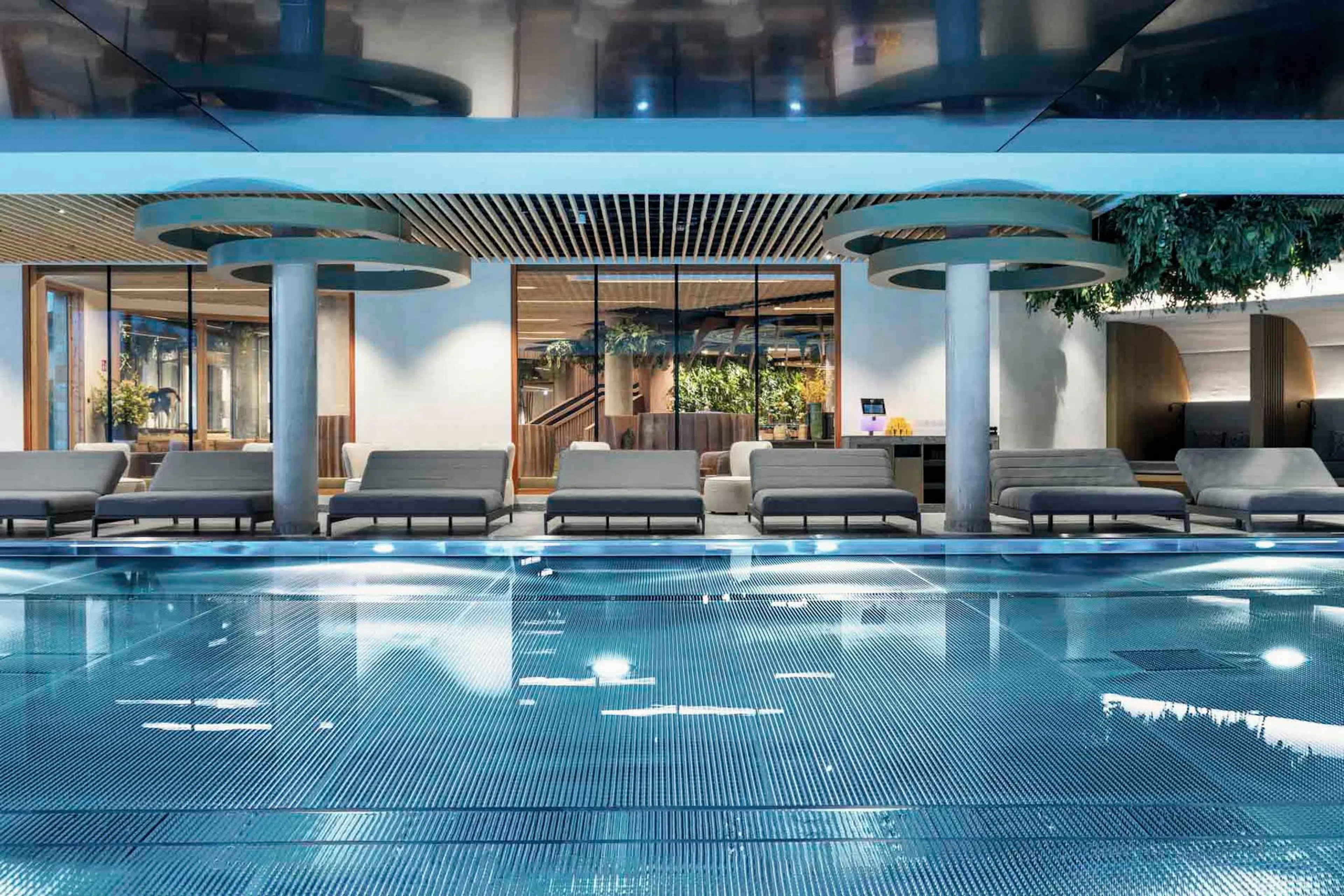 Pool with sun loungers and views into the lobby at The Grand Green – Familux Resort.