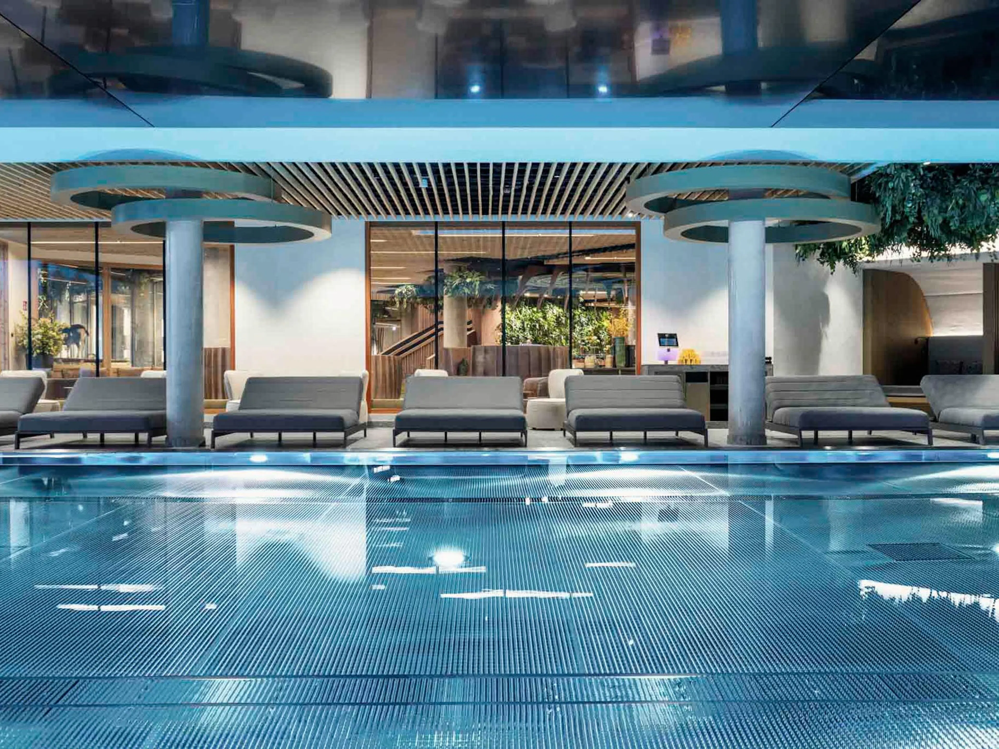 Pool mit Liegen und Blick in die Lobby im The Grand Green - Familux Resort.