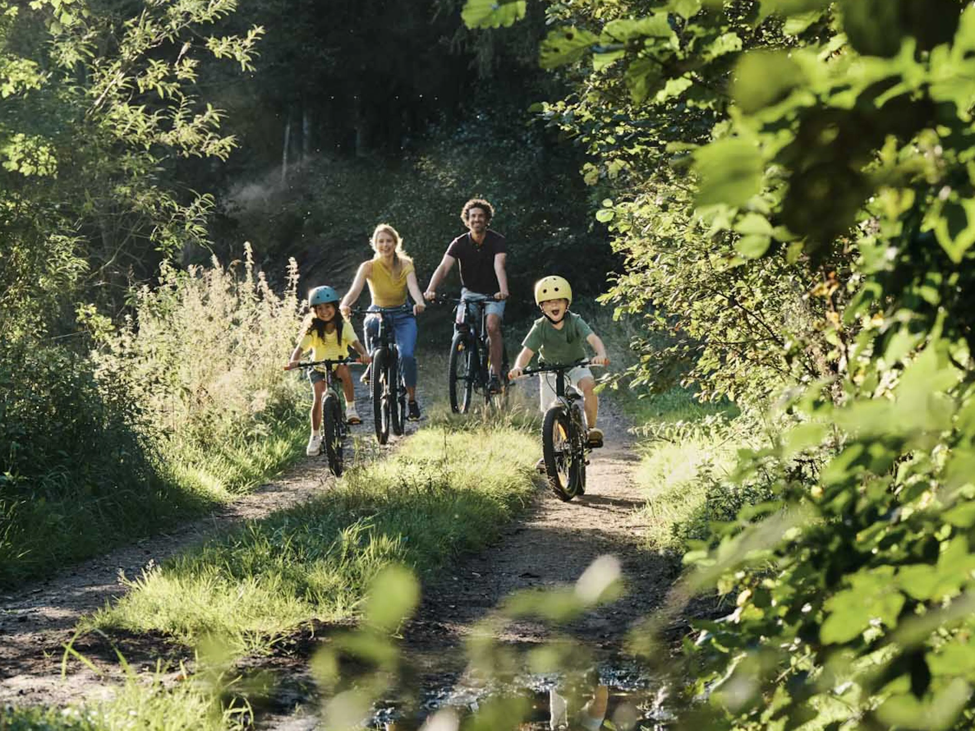 Familie fährt mit Fahrrädern durch den Thüringer Wald.