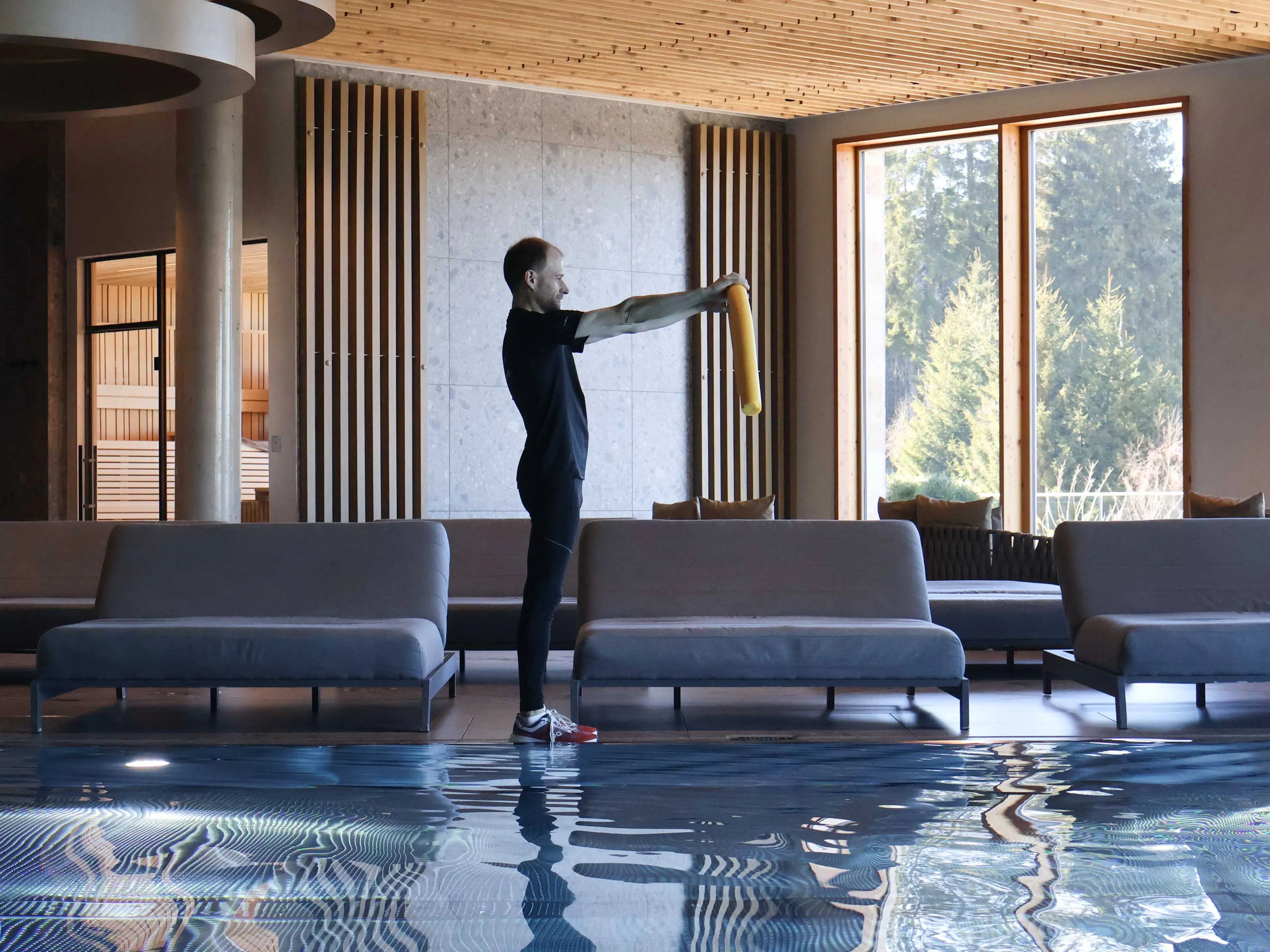 Man demonstrating aqua aerobics exercises in the pool at The Grand Green – Familux Resort.
