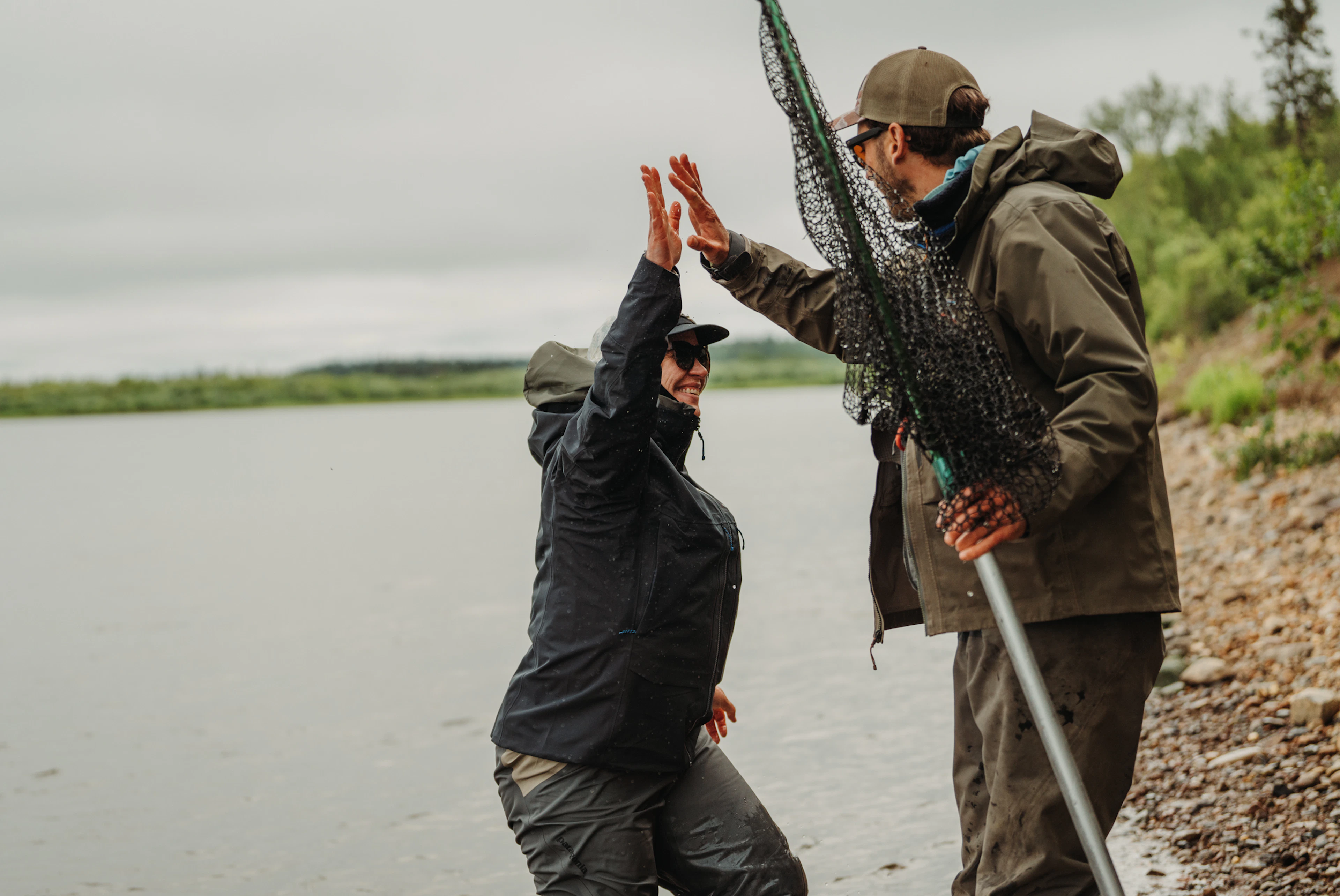 Fly fishing guide and guest celebrating a catch in Bristol Bay Alaska during a guided fishing trip