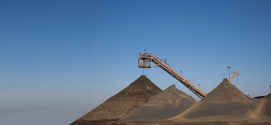 Hijskraan die boven een piramide hangt.