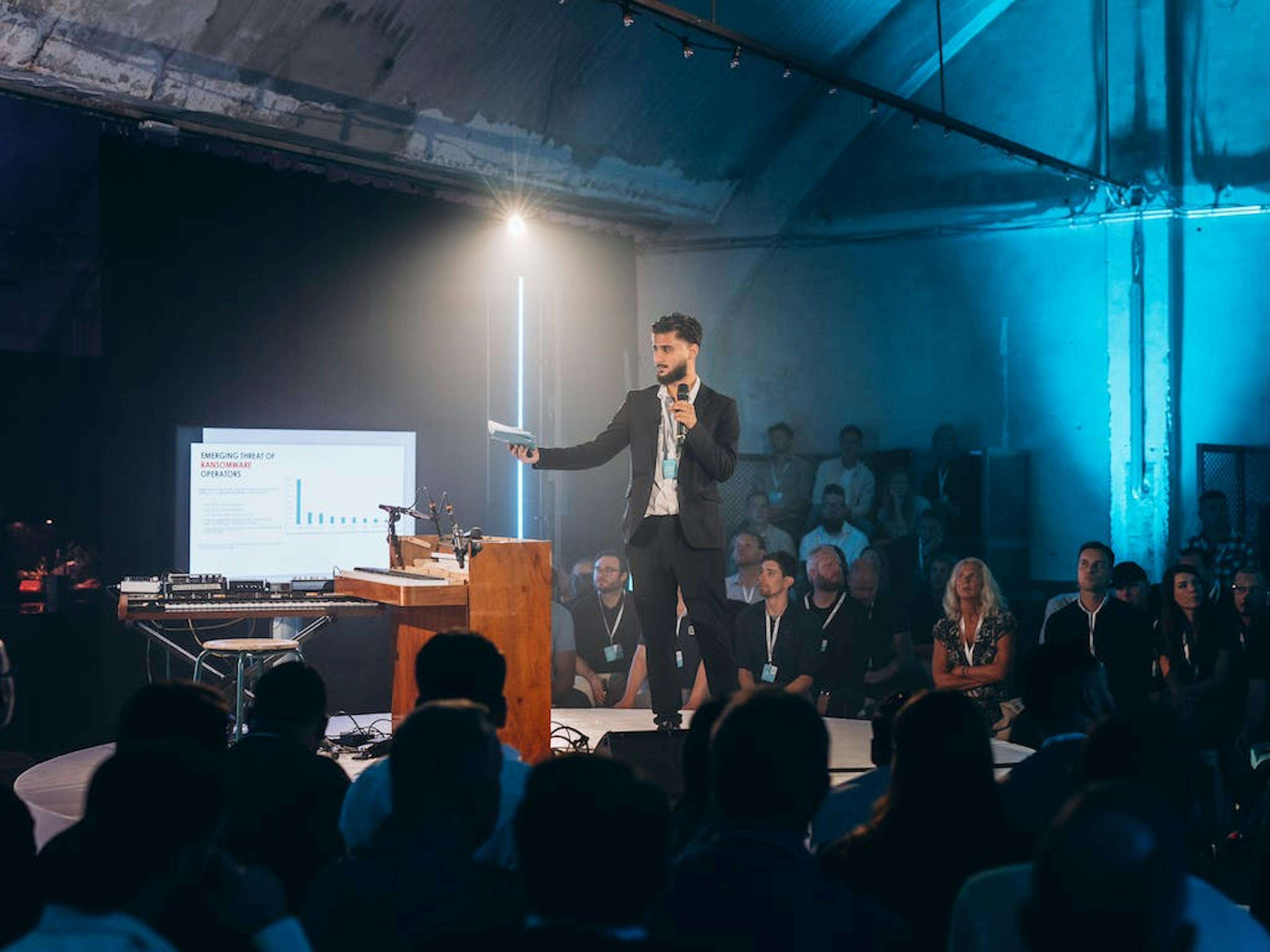 Spreker Emirhan Sarikaya presenteert tijdens The.NextGen TechKnowFest 2023.