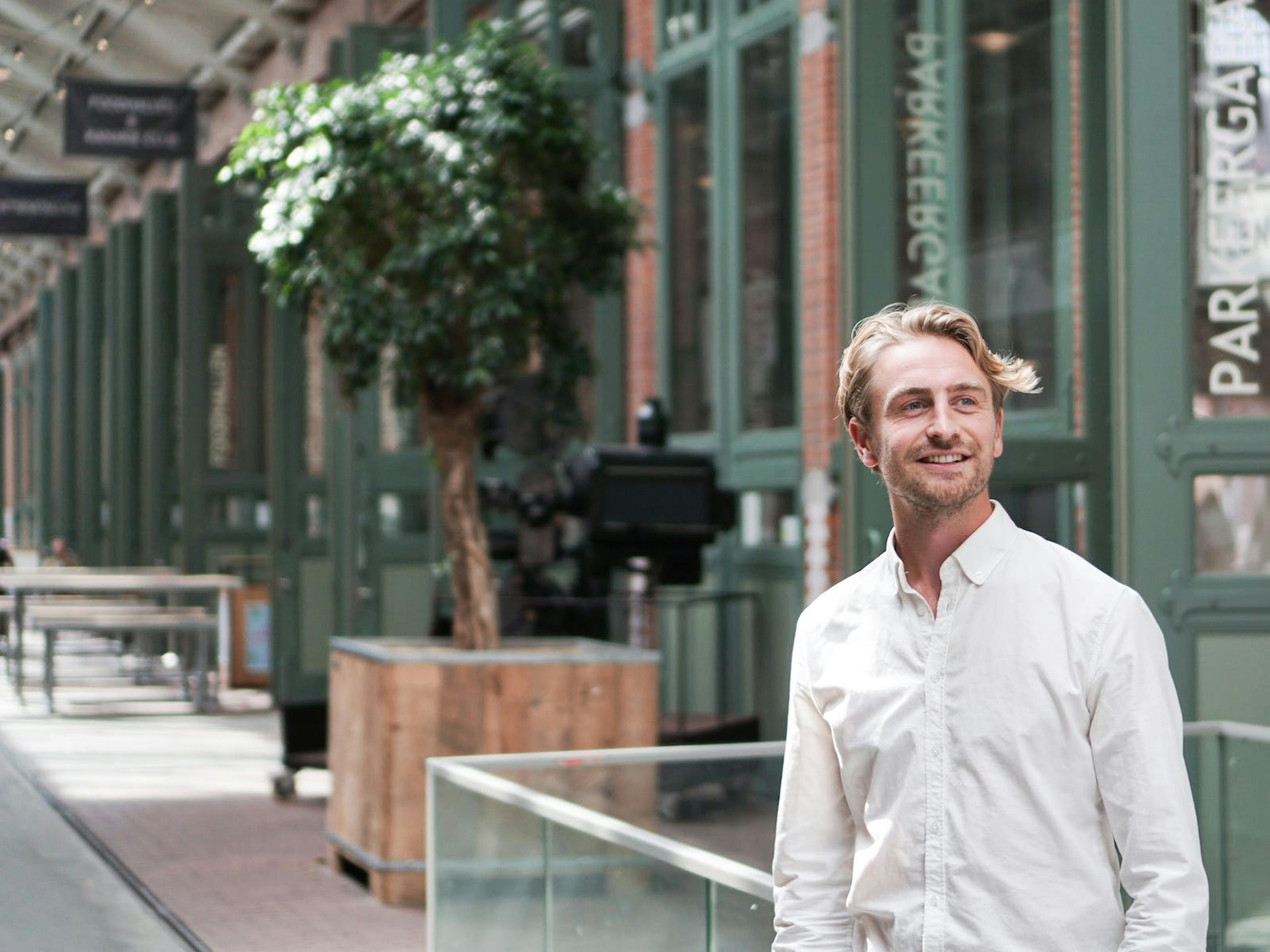 IT Specialist Pierre Borst staat lachend in de centrale hal van de filmhallen in Amsterdam. 