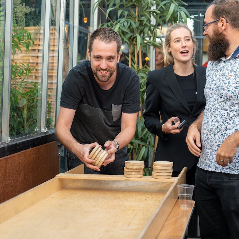Lachende collega's tijdens het sjoelen.